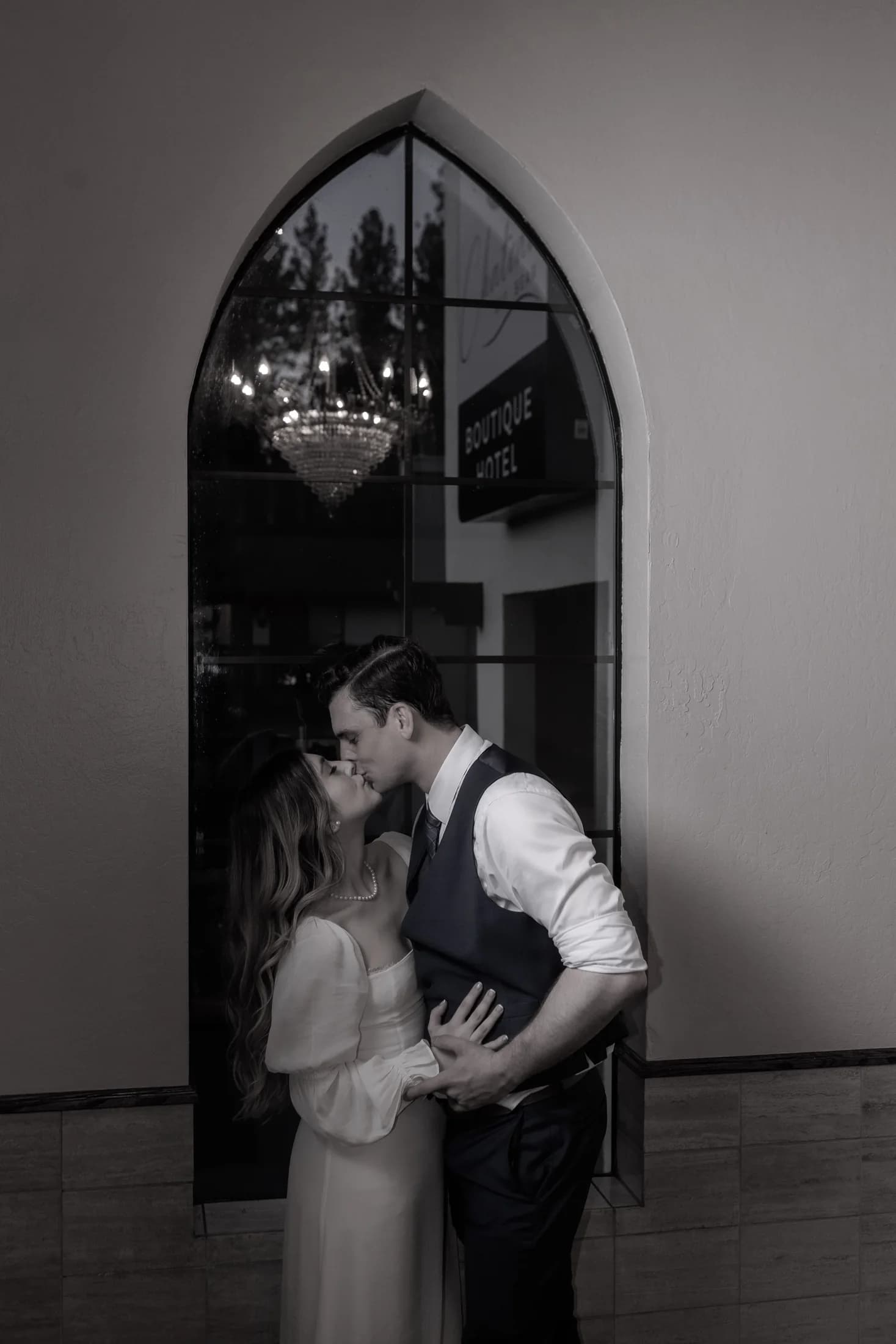 Black-and-white portrait of Gloria and Ryan beneath an arched window