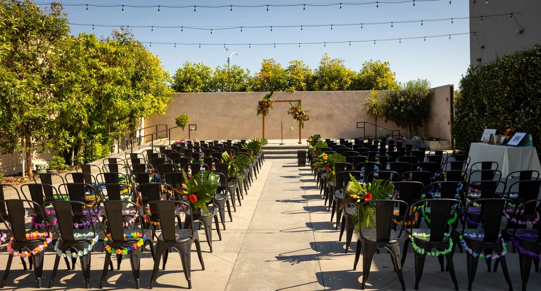 Empty outdoor ceremony seating and floral arch at Hangar 21 South