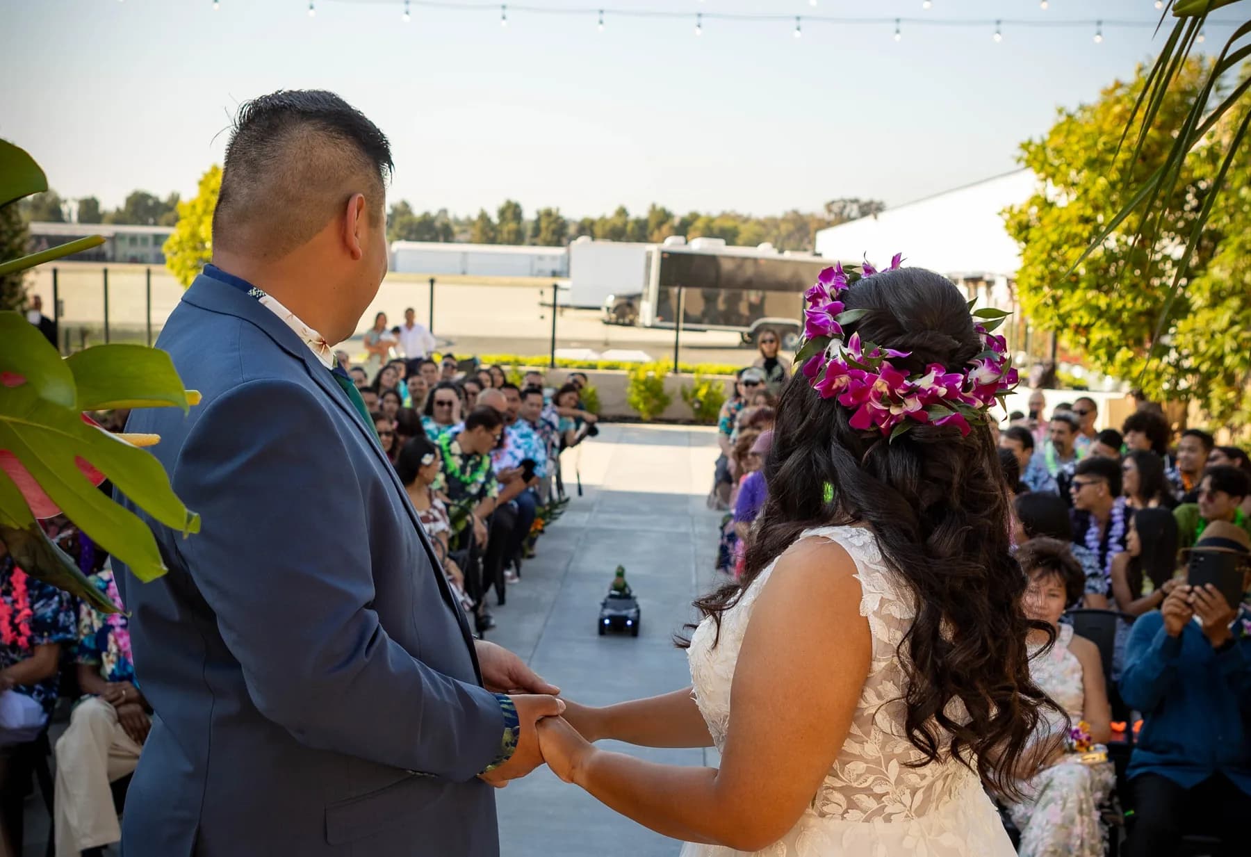 Jed and Azalea holding hands during their outdoor ceremony