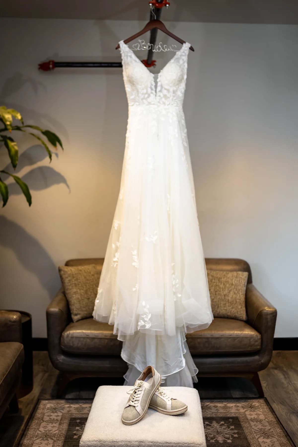 Azalea’s wedding dress hanging above her shoes in the preparation room