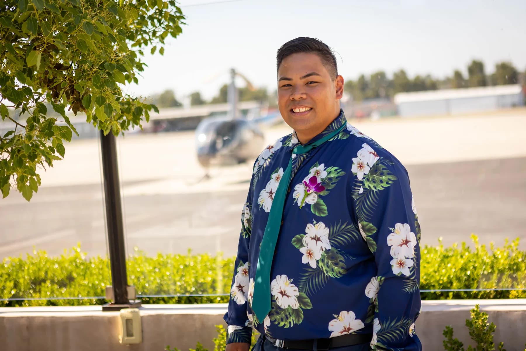 Portrait of Jed in his blue floral shirt near the airfield