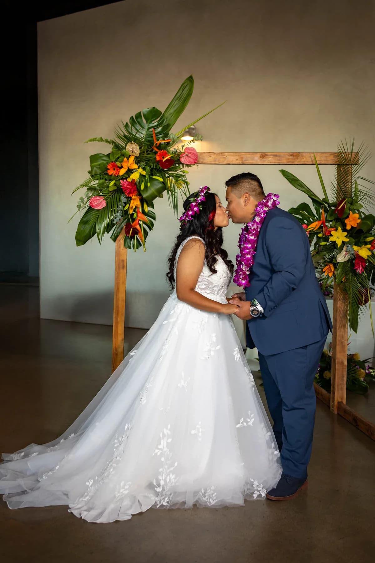 Jed and Azalea sharing a quiet portrait beneath the ceremony flowers