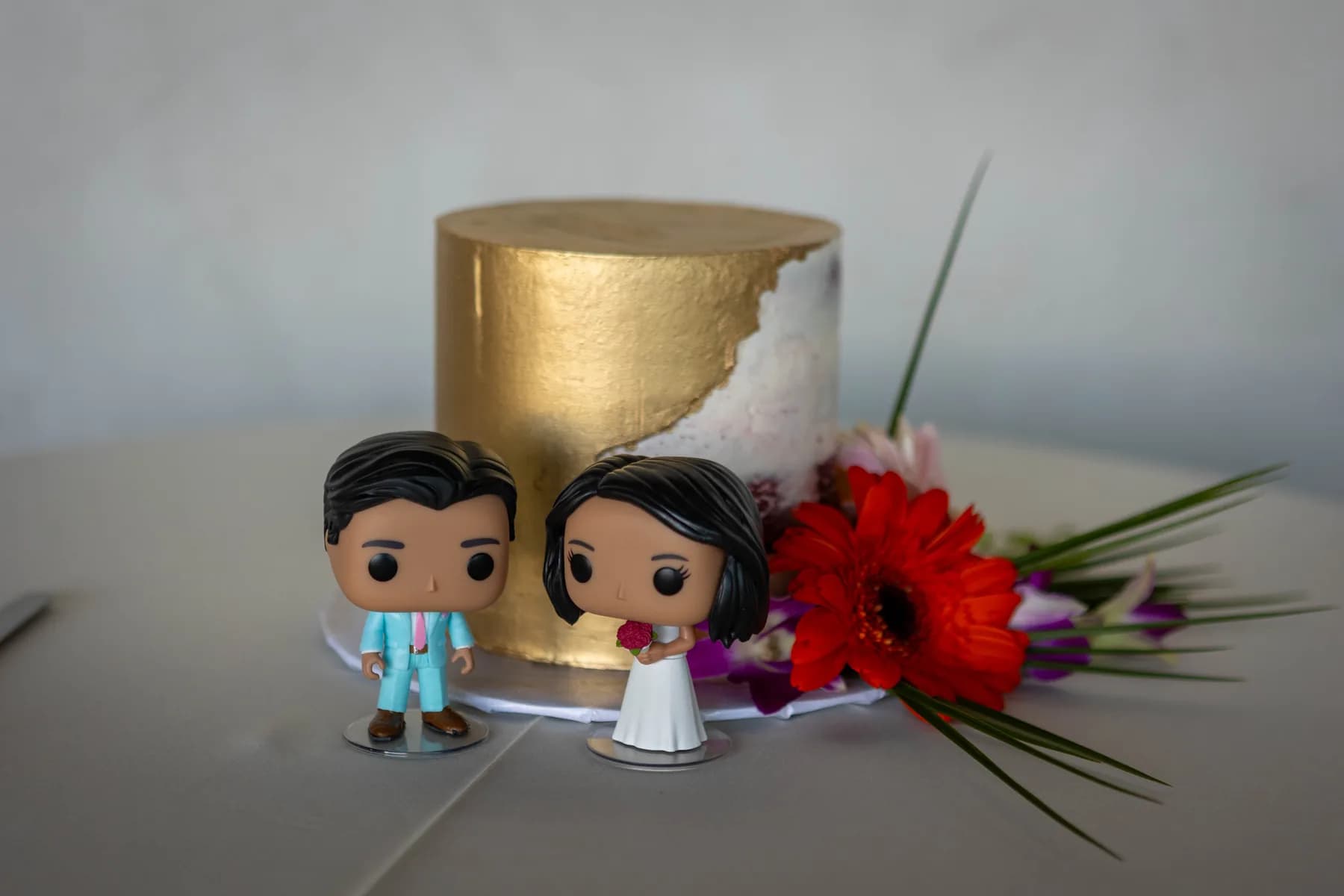 Small bride-and-groom figures displayed with flowers