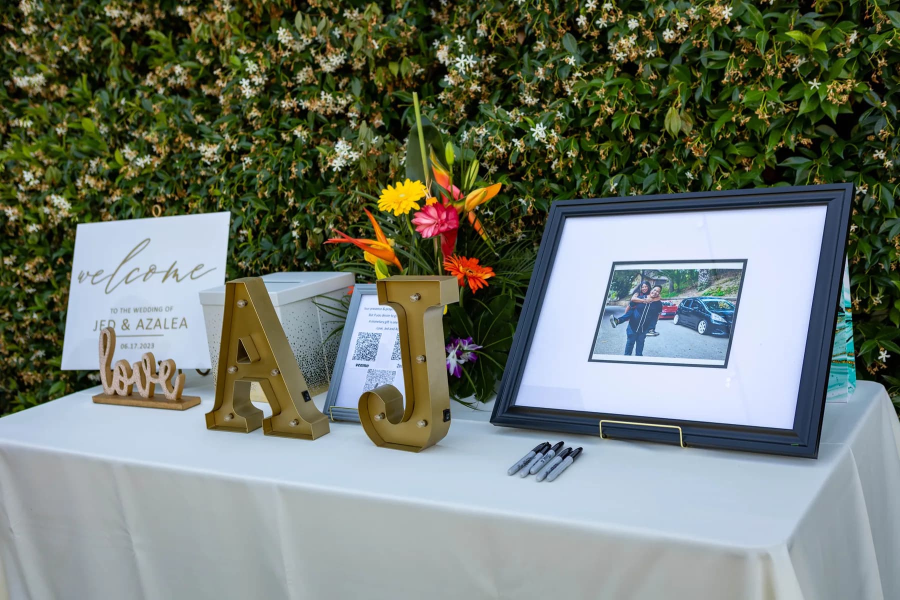 Personalized wedding welcome table with flowers and framed photographs