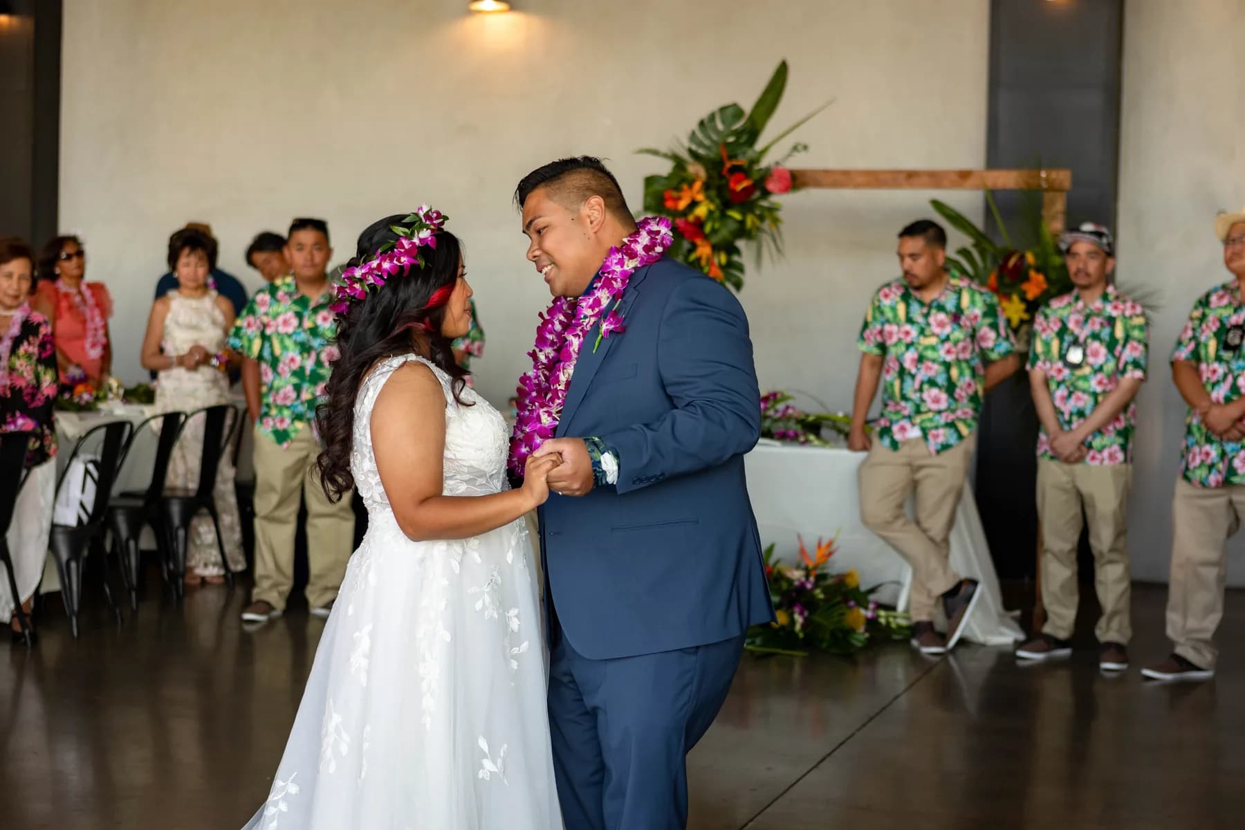Jed and Azalea dancing beneath tropical floral arrangements