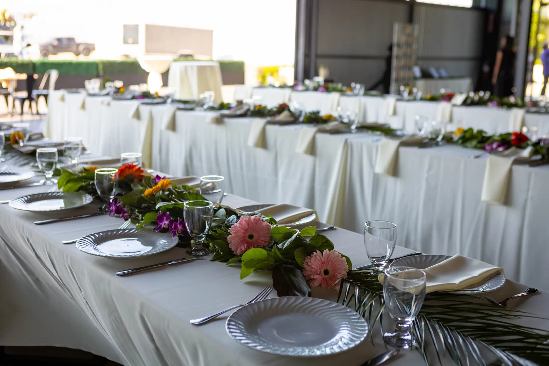 Tropical flowers and place settings on a wedding reception table