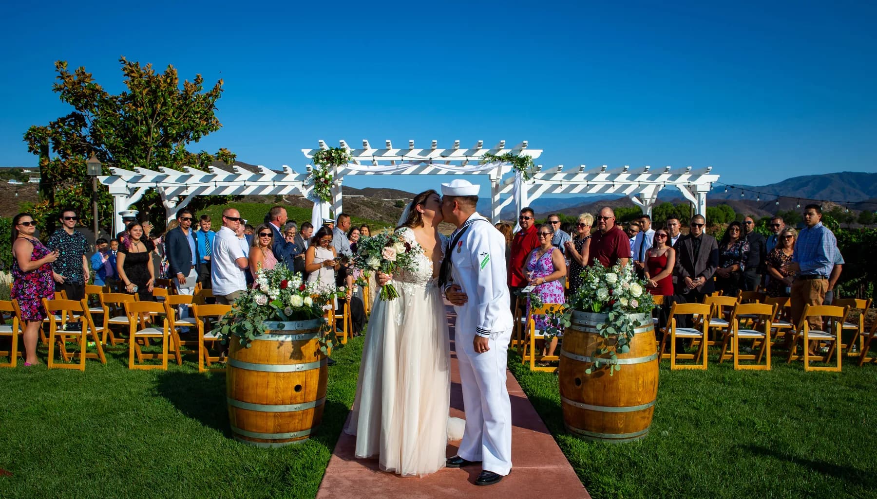 Newlyweds walking back down the aisle beneath a vivid blue sky