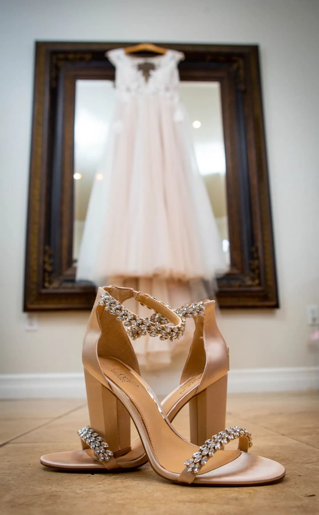 Wedding dress and jeweled shoes arranged together before the ceremony