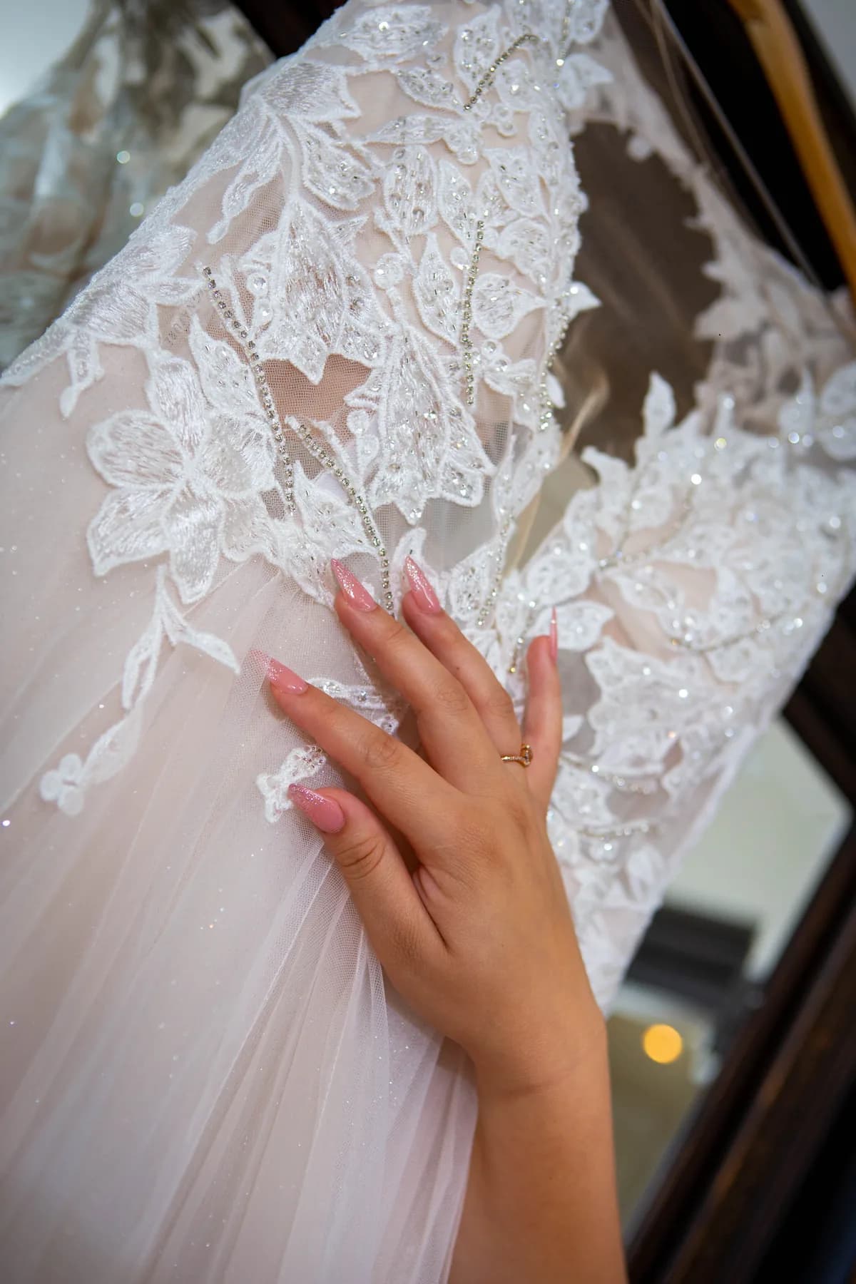 Deidriana touching the lace detail of her wedding dress