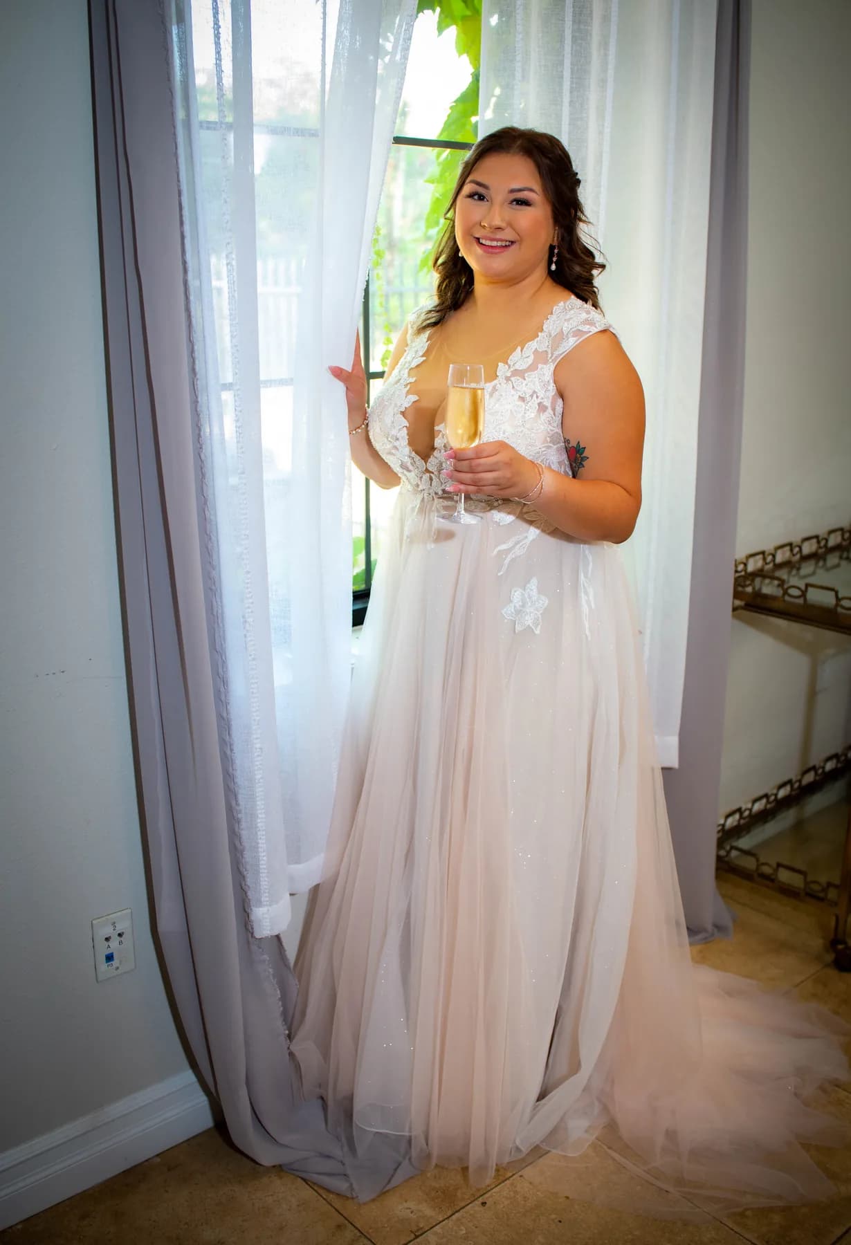 Deidriana holding her bouquet beside a bright window