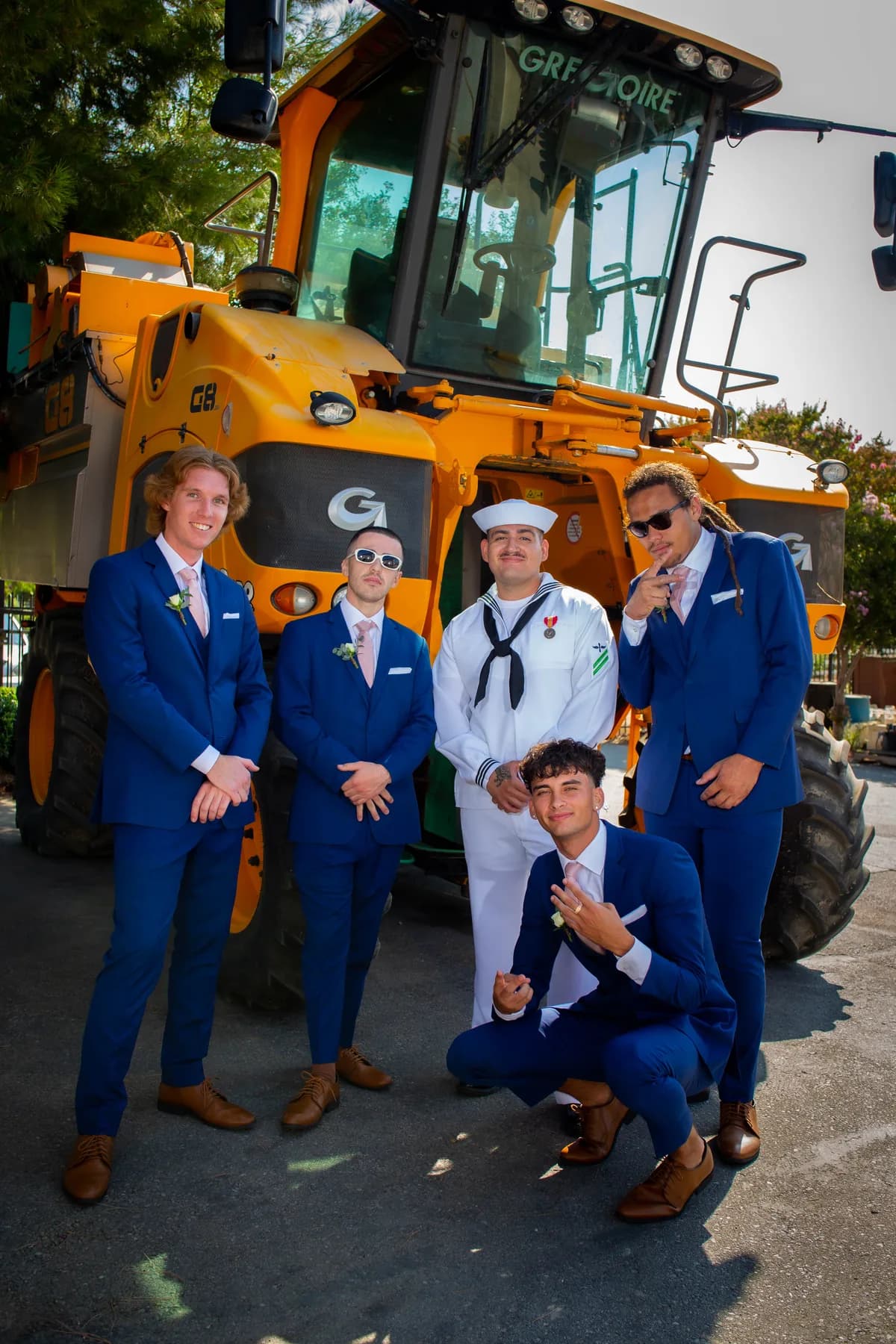 Gustavo and attendants posing beside construction equipment