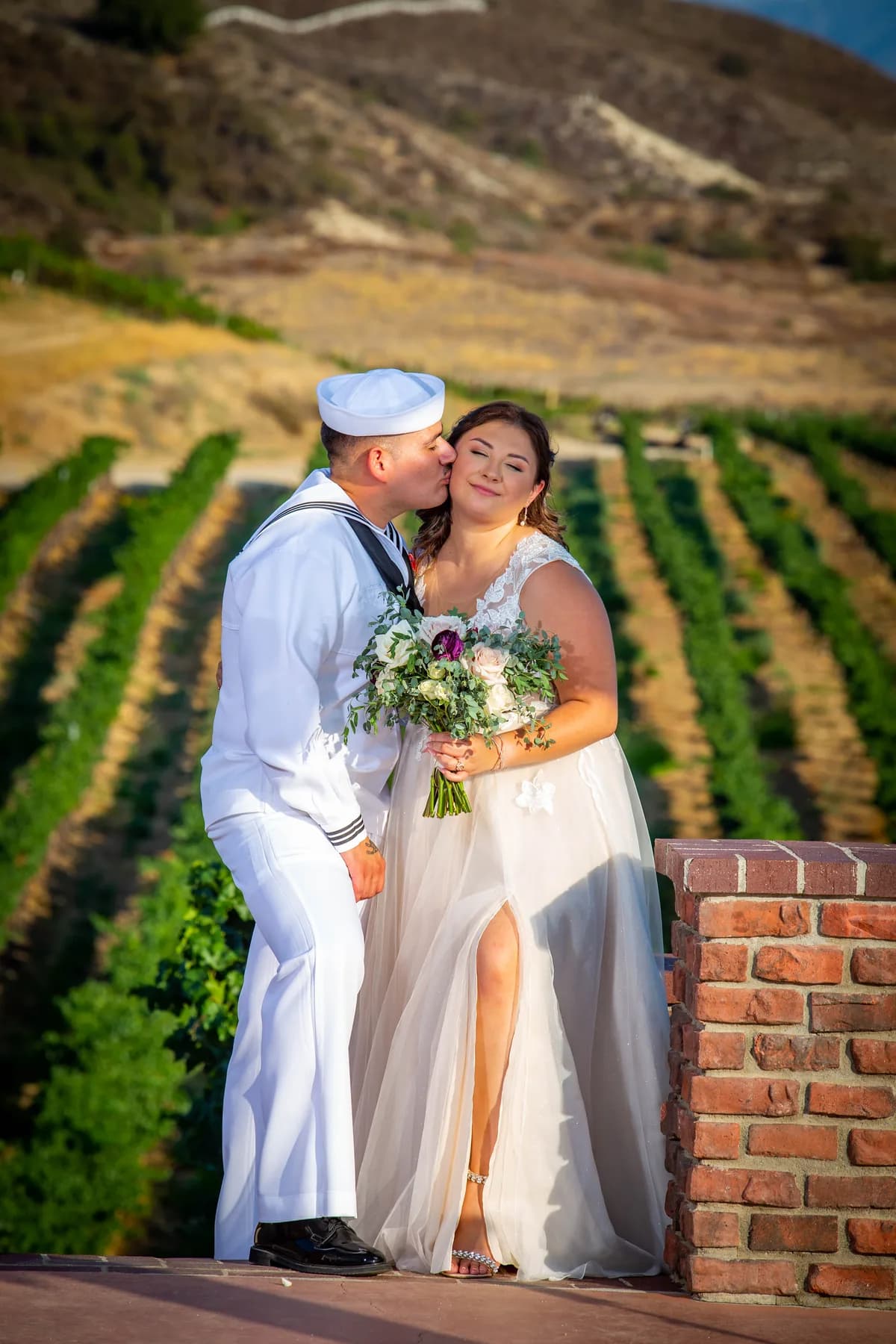 Deidriana and Gustavo standing together among vineyard rows