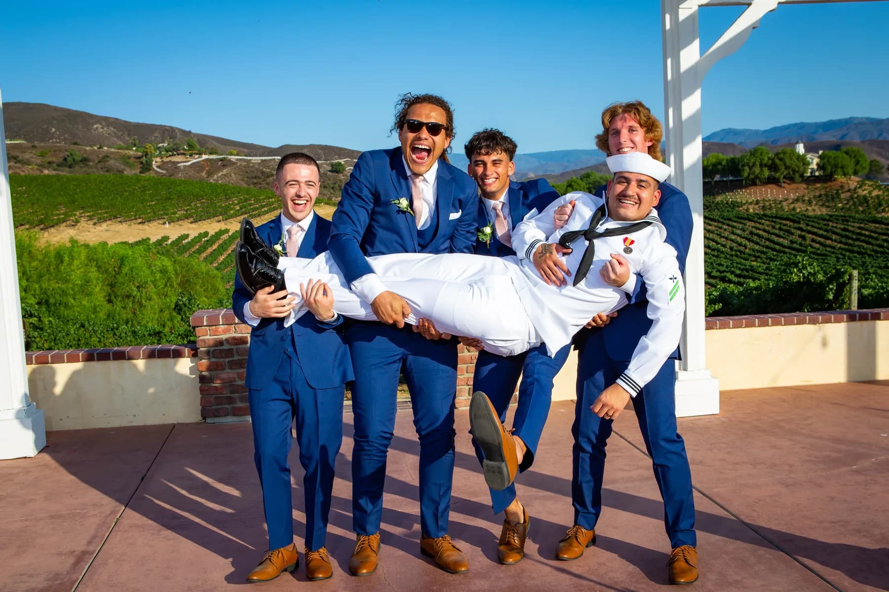 Attendants lifting Gustavo during a playful wedding portrait