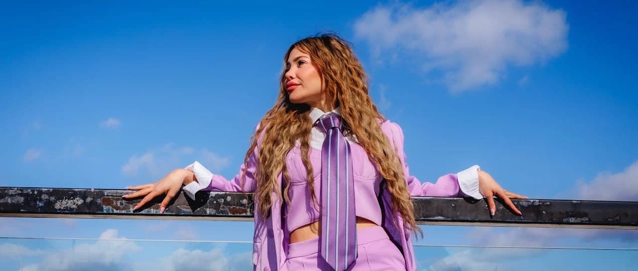 Side-facing rooftop portrait against a blue sky