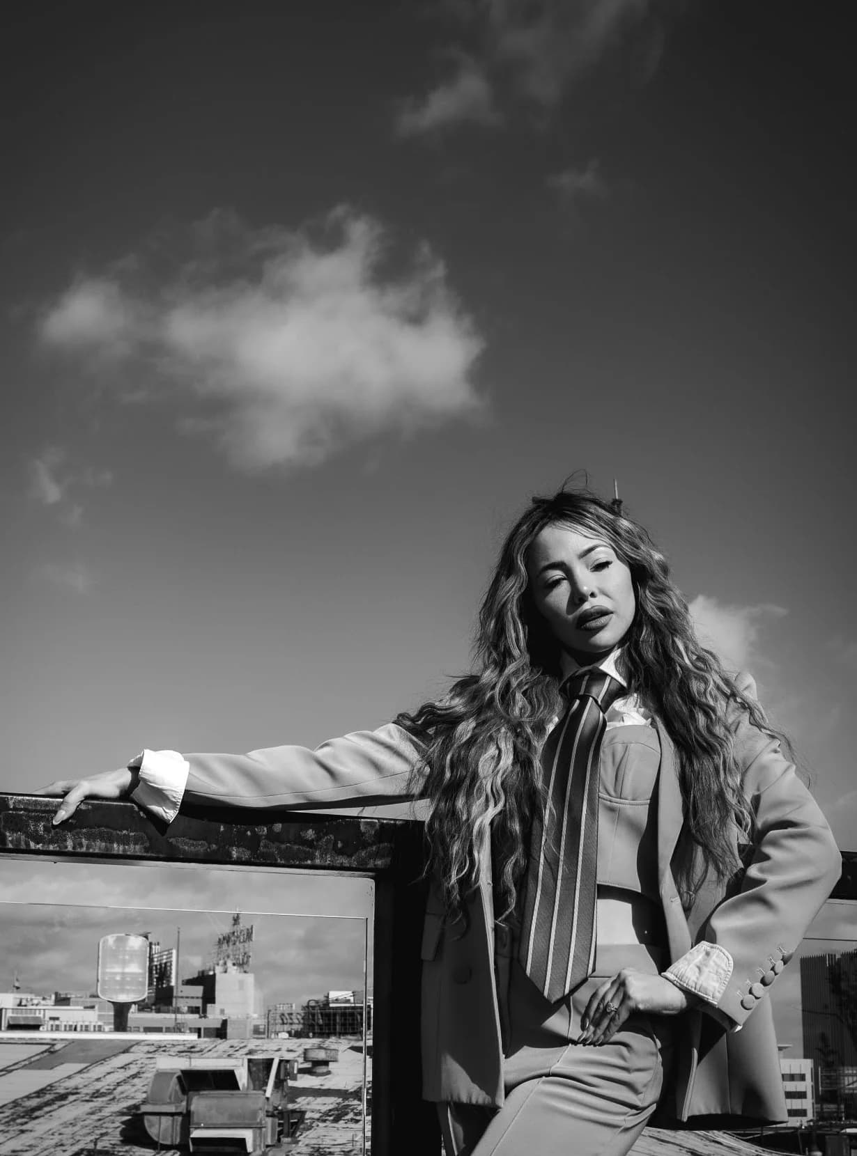 Black-and-white portrait with an arm resting on the railing
