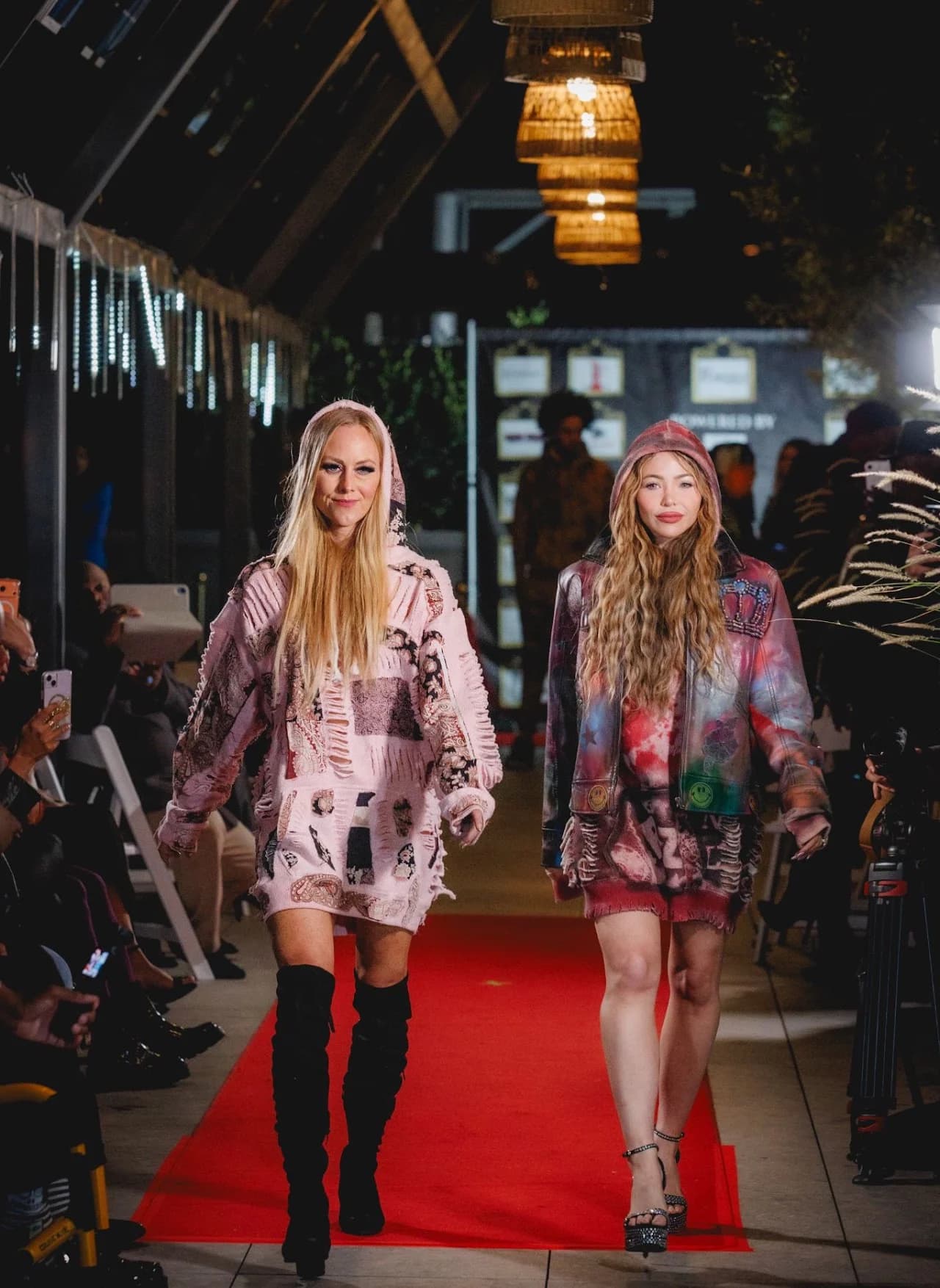 Two models walking along a red runway