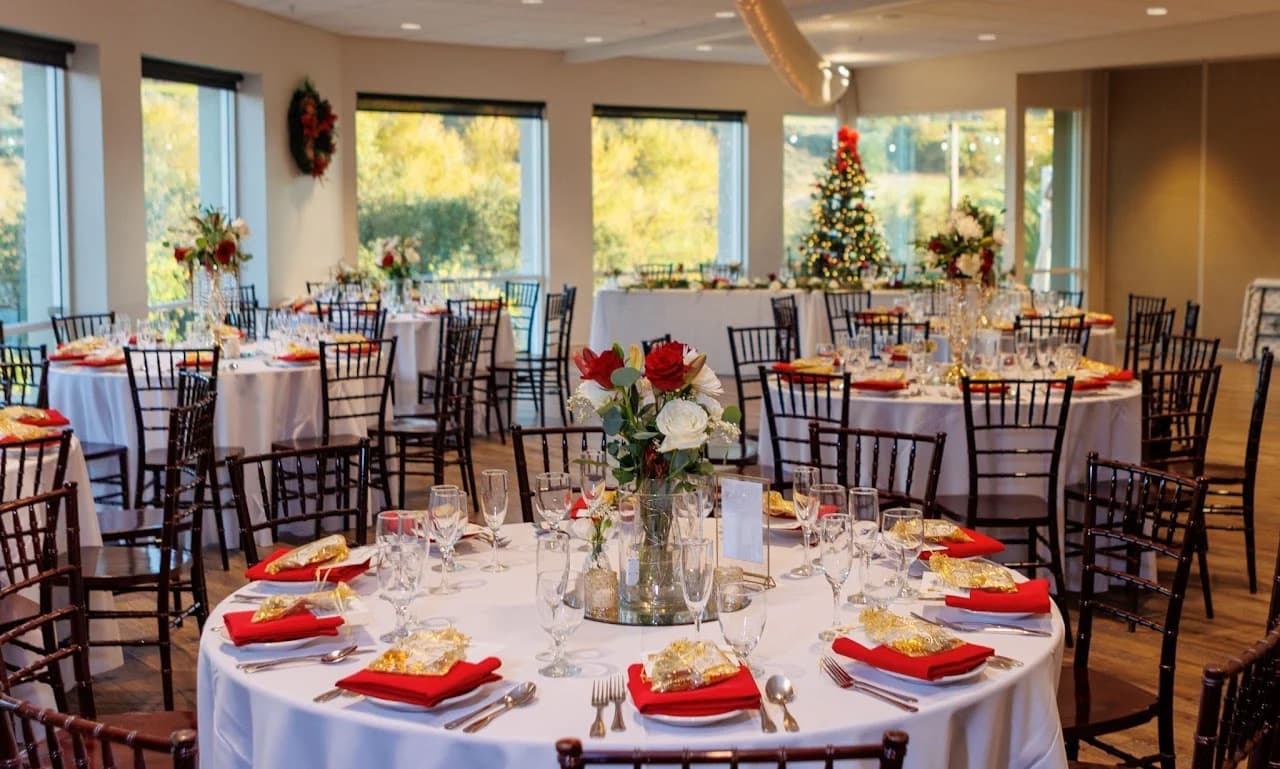 Reception tables arranged with red napkins and floral centerpieces