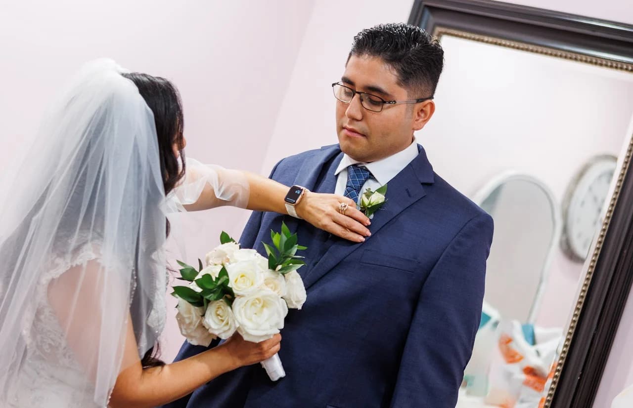 A man helping adjust a veil