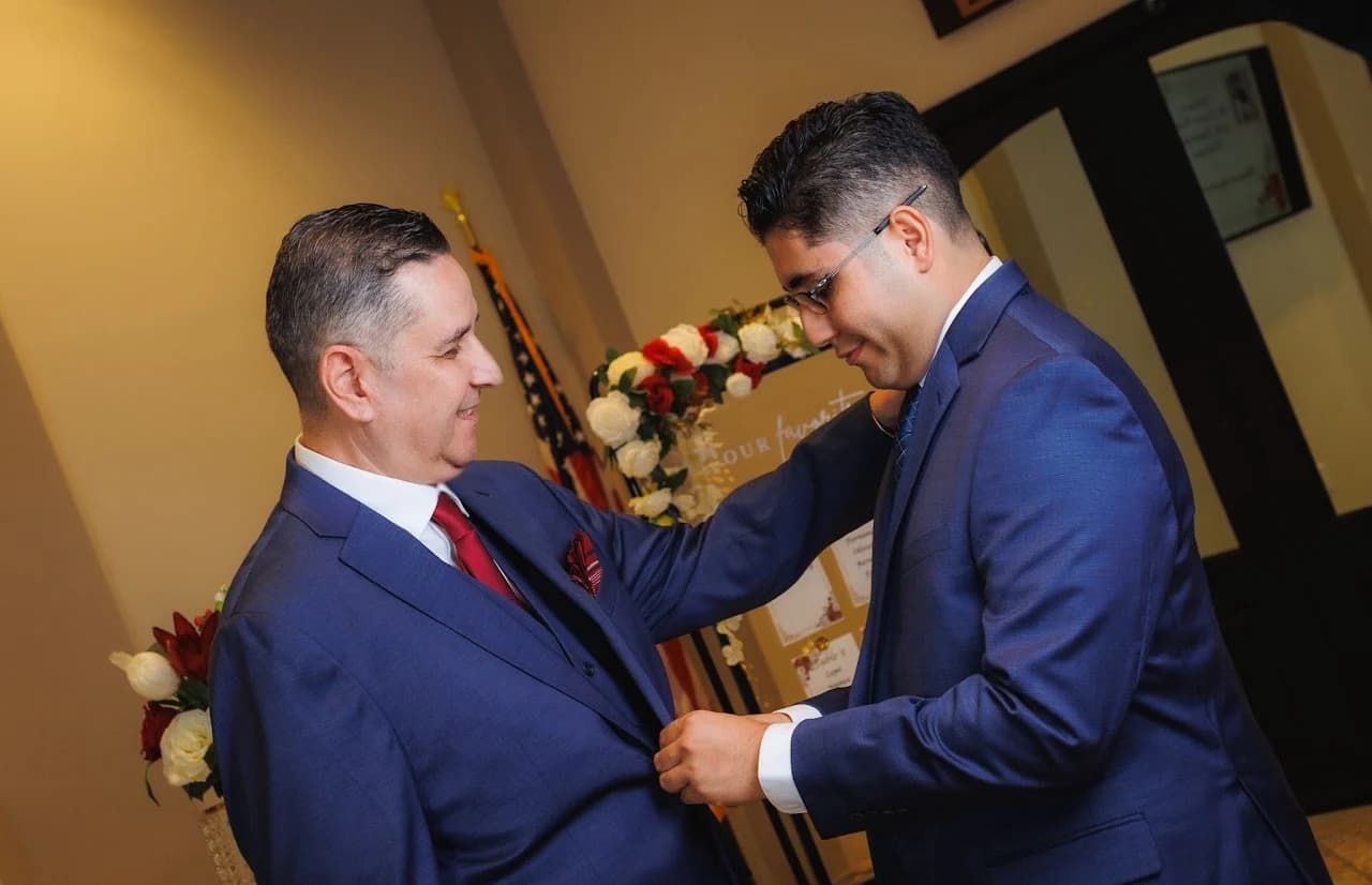Two men adjusting formalwear