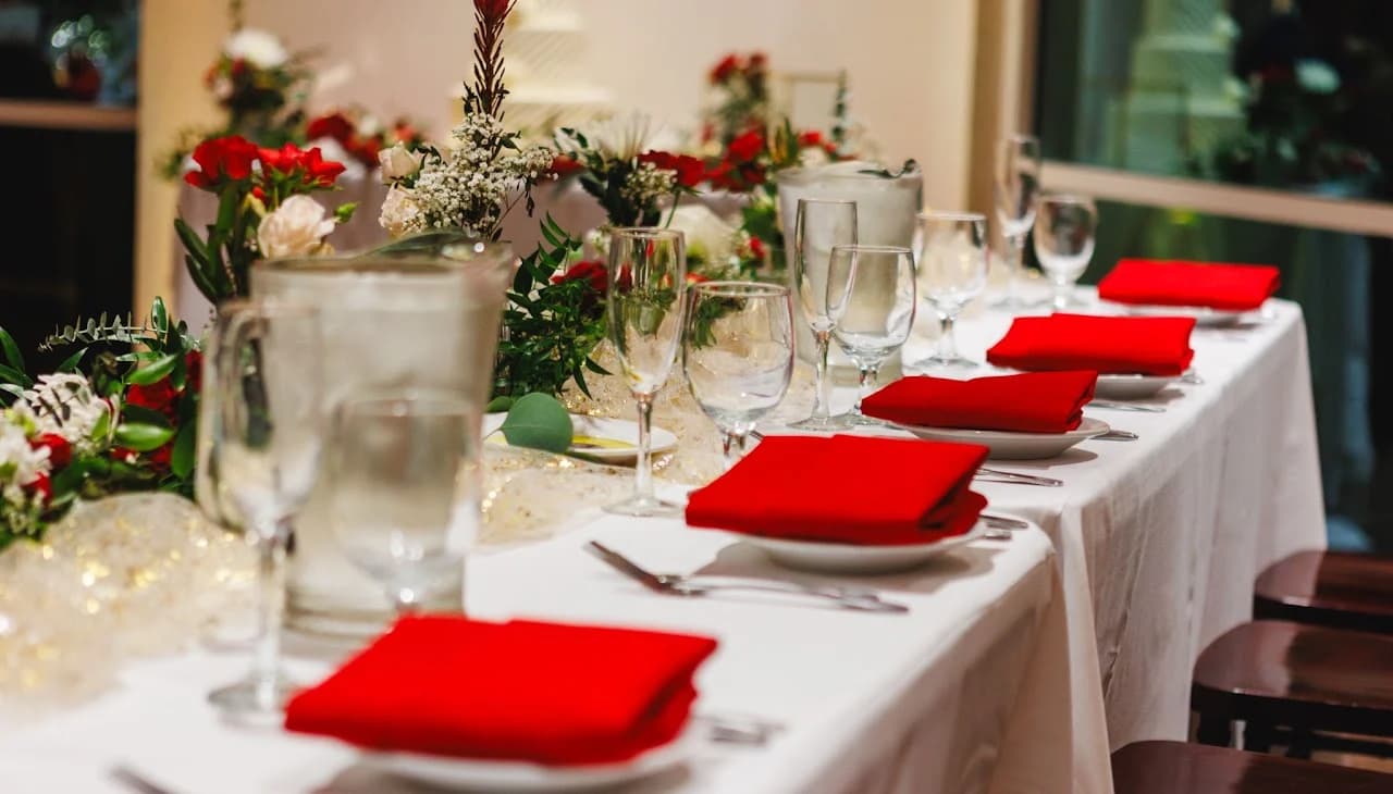 Red napkins and glassware along a white table