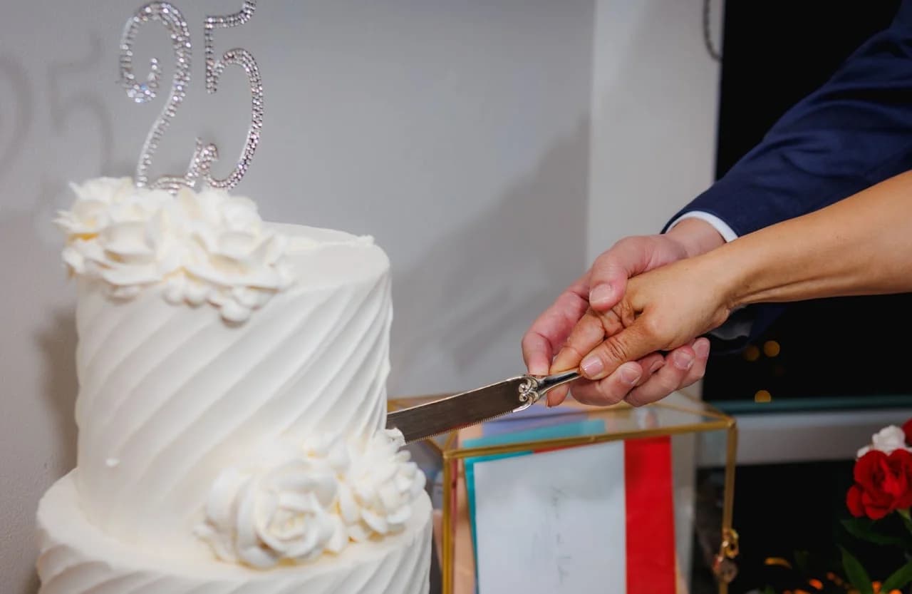 Hands cutting the anniversary cake