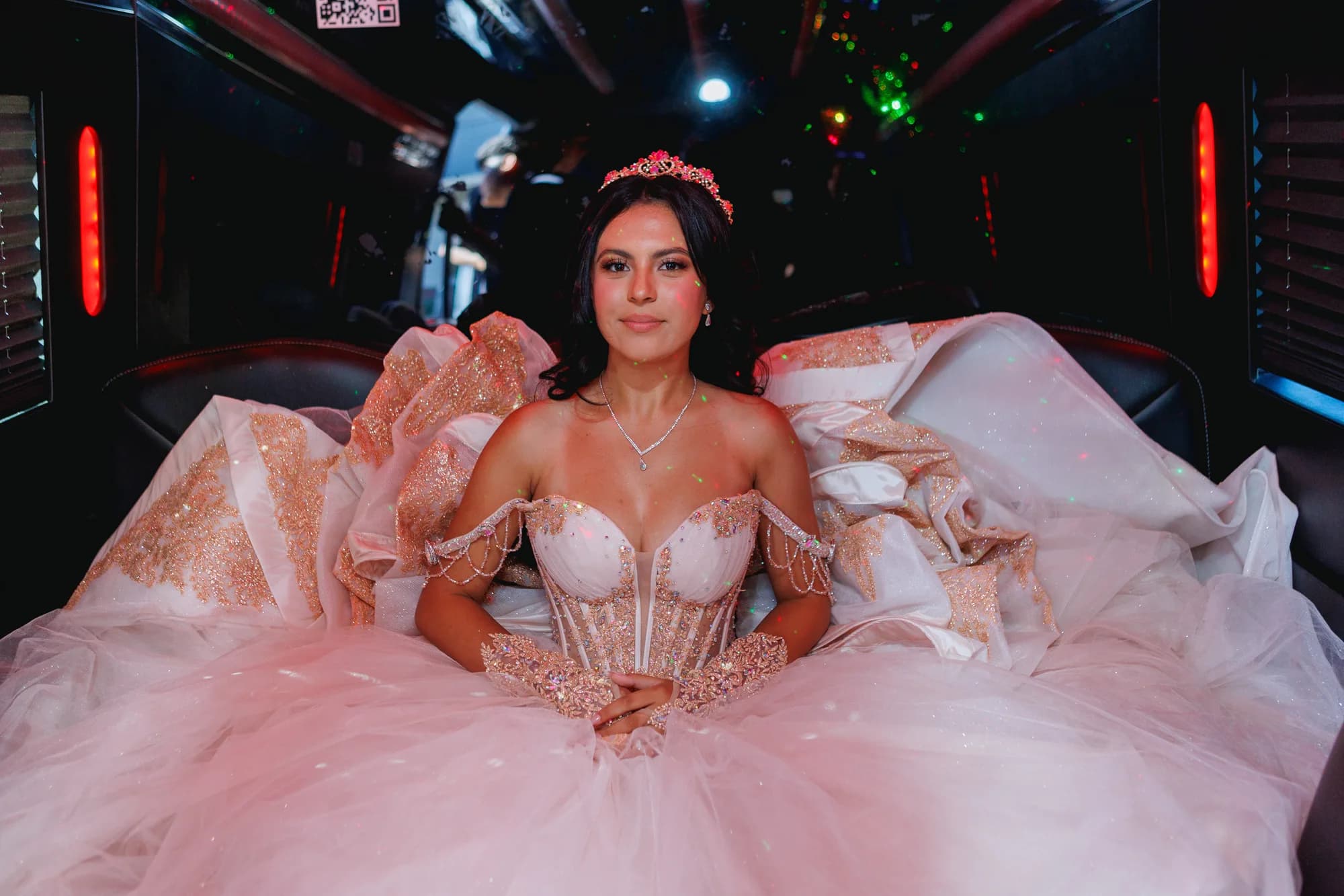 Isabella seated in her blush gown inside the party vehicle