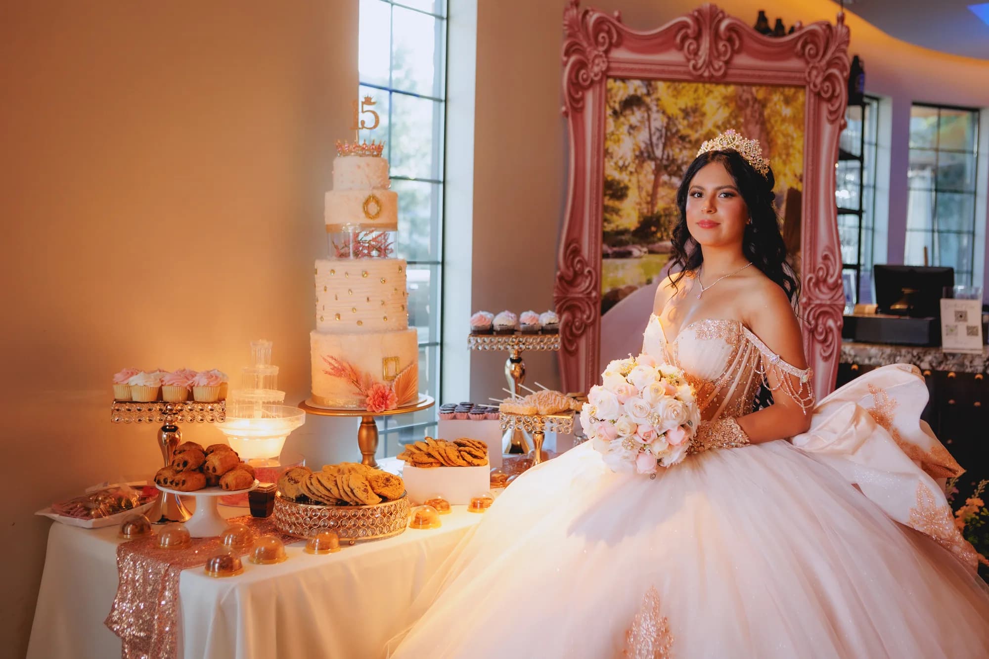 Isabella seated beside her quinceañera dessert table