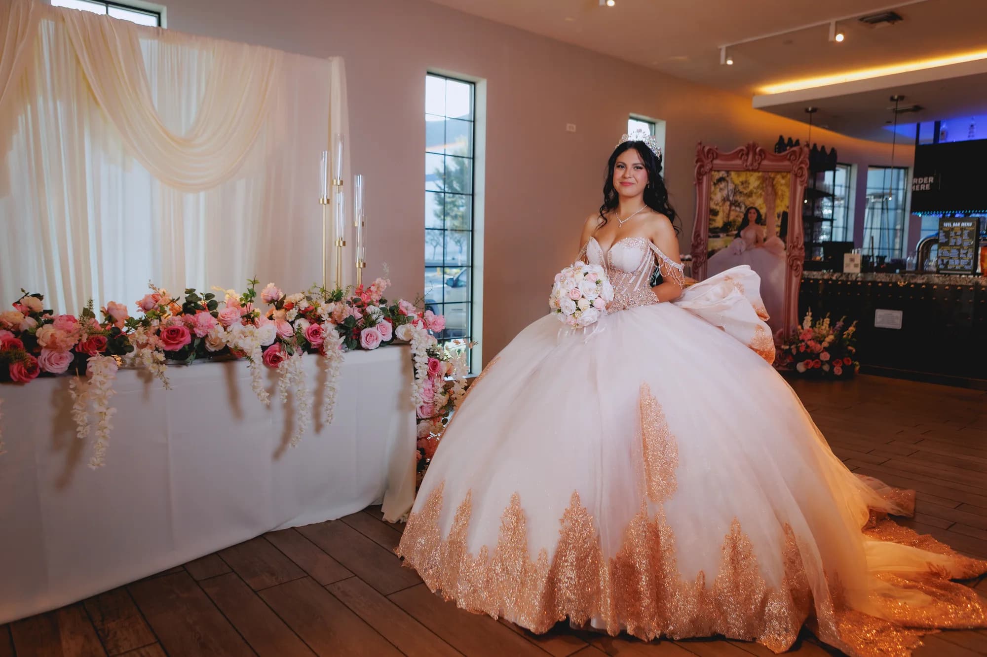 Isabella standing beside the flower-covered reception table
