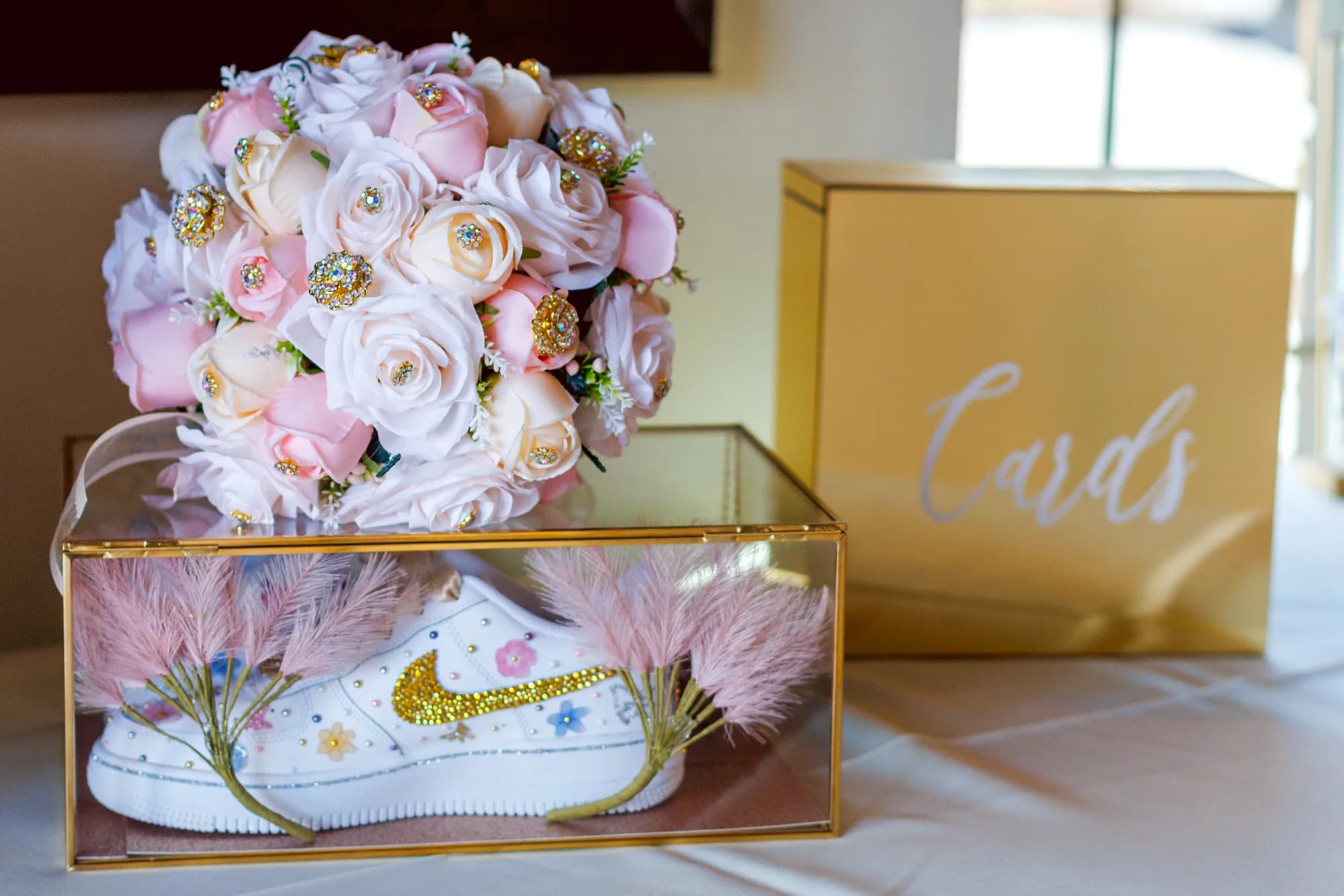 Pink and ivory bouquet beside a gold Cards sign