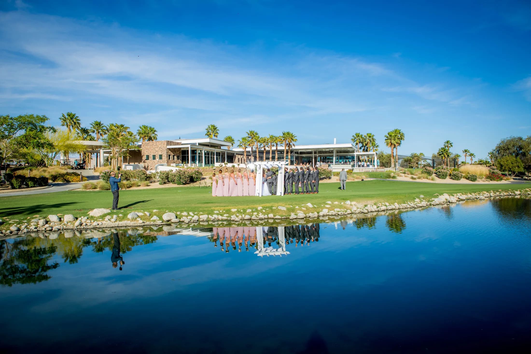 Escena Golf Club reflected in water beneath a bright Palm Springs sky