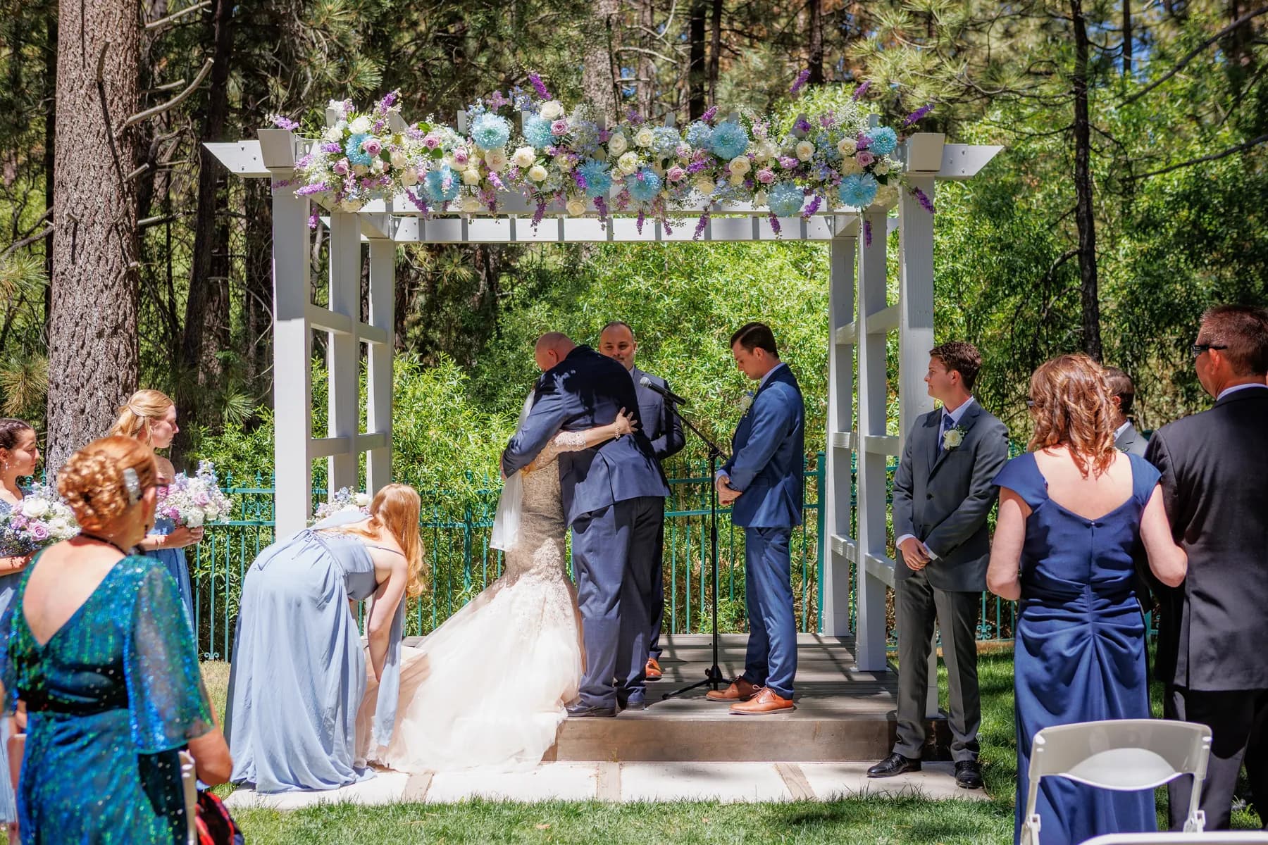 Gloria and Ryan standing beneath the floral arbor during their ceremony