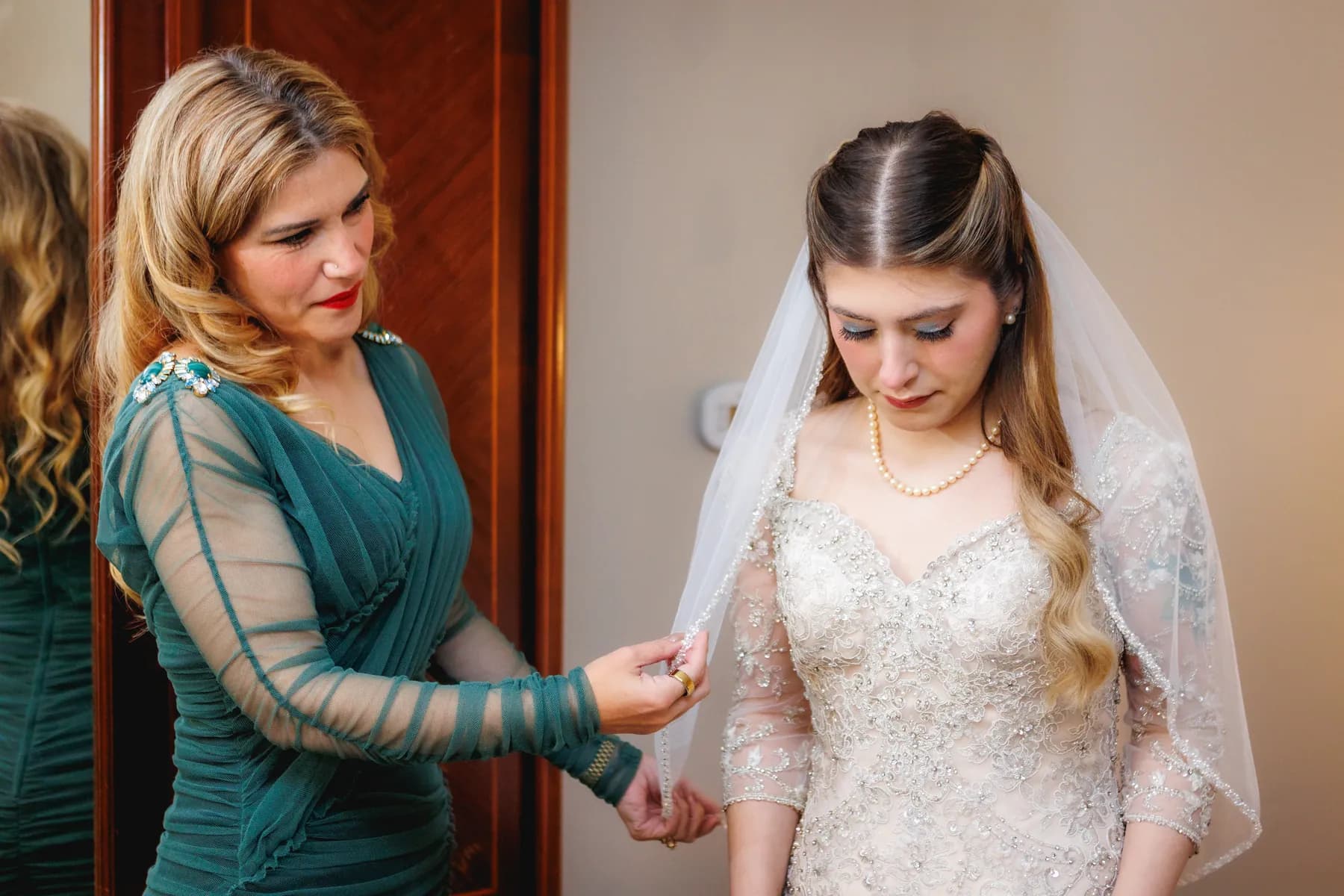 A companion checking the sleeve of Gloria's wedding dress