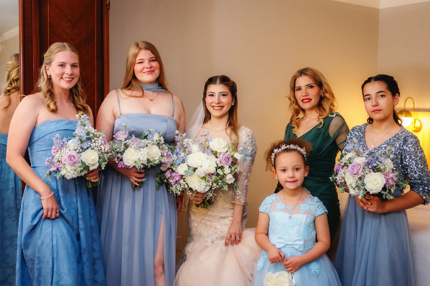 Gloria with companions holding bouquets during wedding preparations
