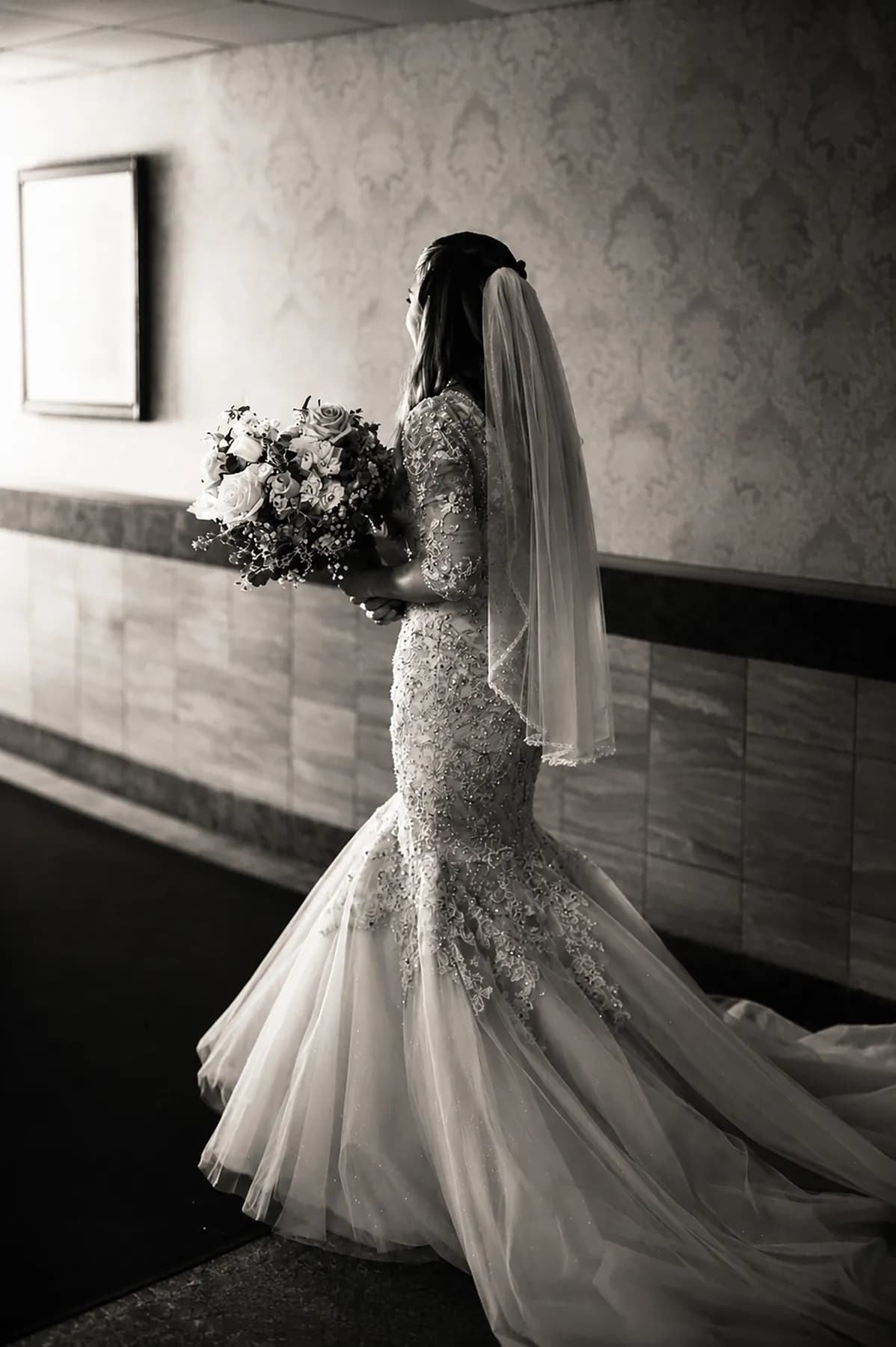 Black-and-white side portrait of Gloria with her veil and bouquet