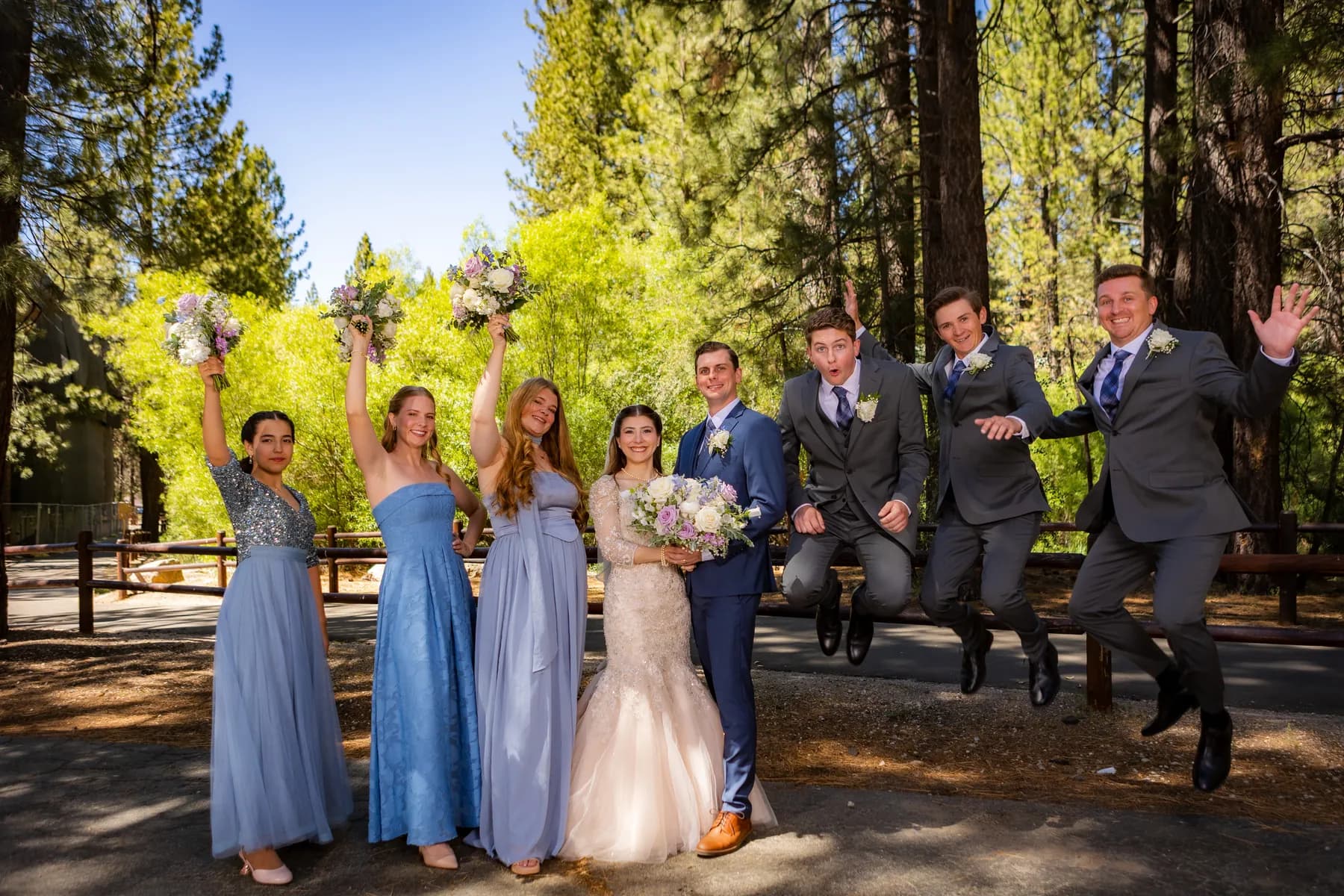 Gloria and Ryan with companions jumping on a sunlit path