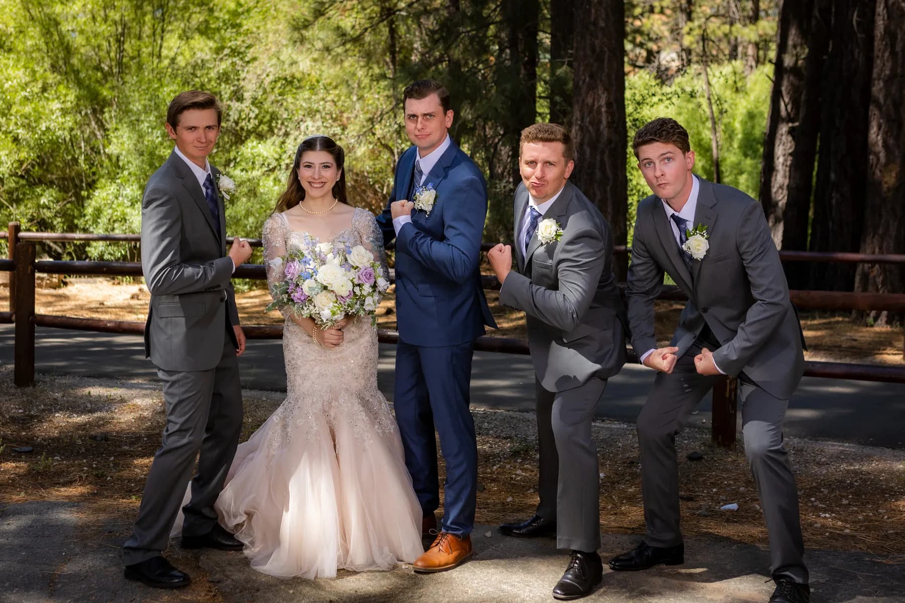 Gloria and Ryan posing with three companions beside a wooden fence