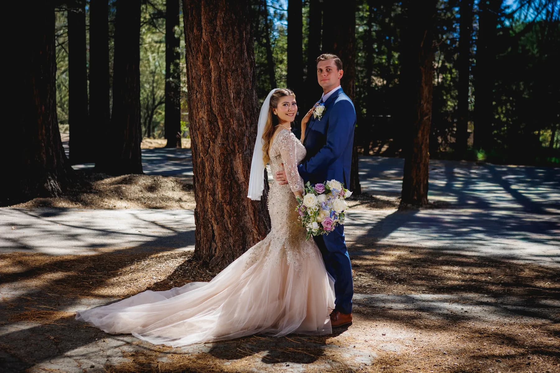 Gloria and Ryan facing one another between pine trees