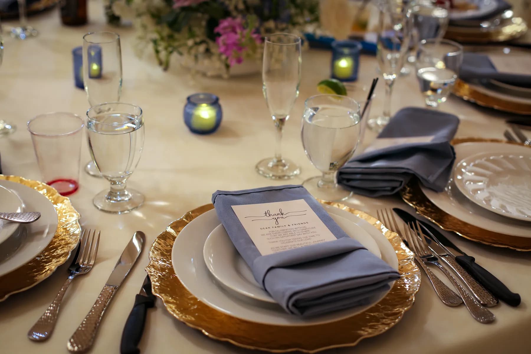 Place setting with a blue napkin and printed card at the reception
