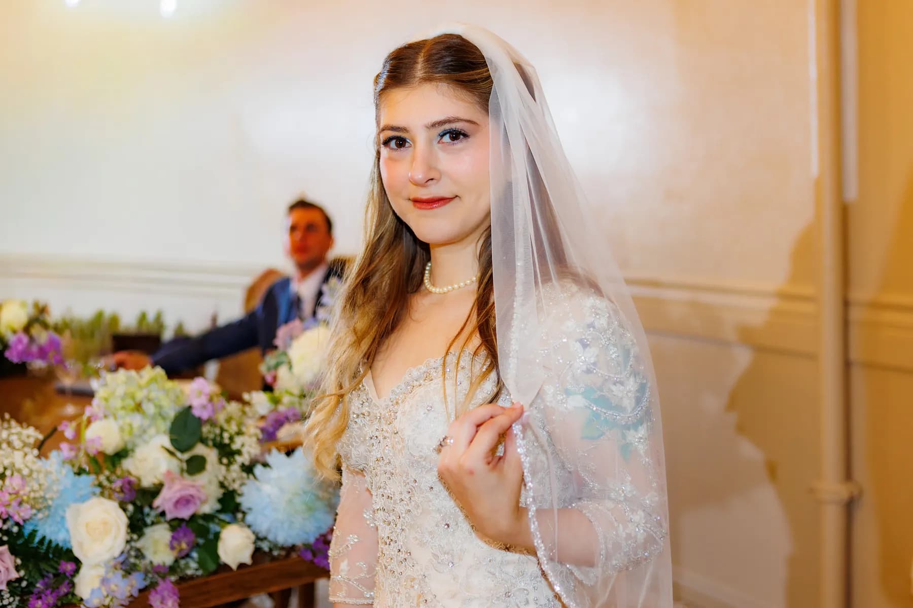 Gloria holding her bouquet for a portrait inside the reception room