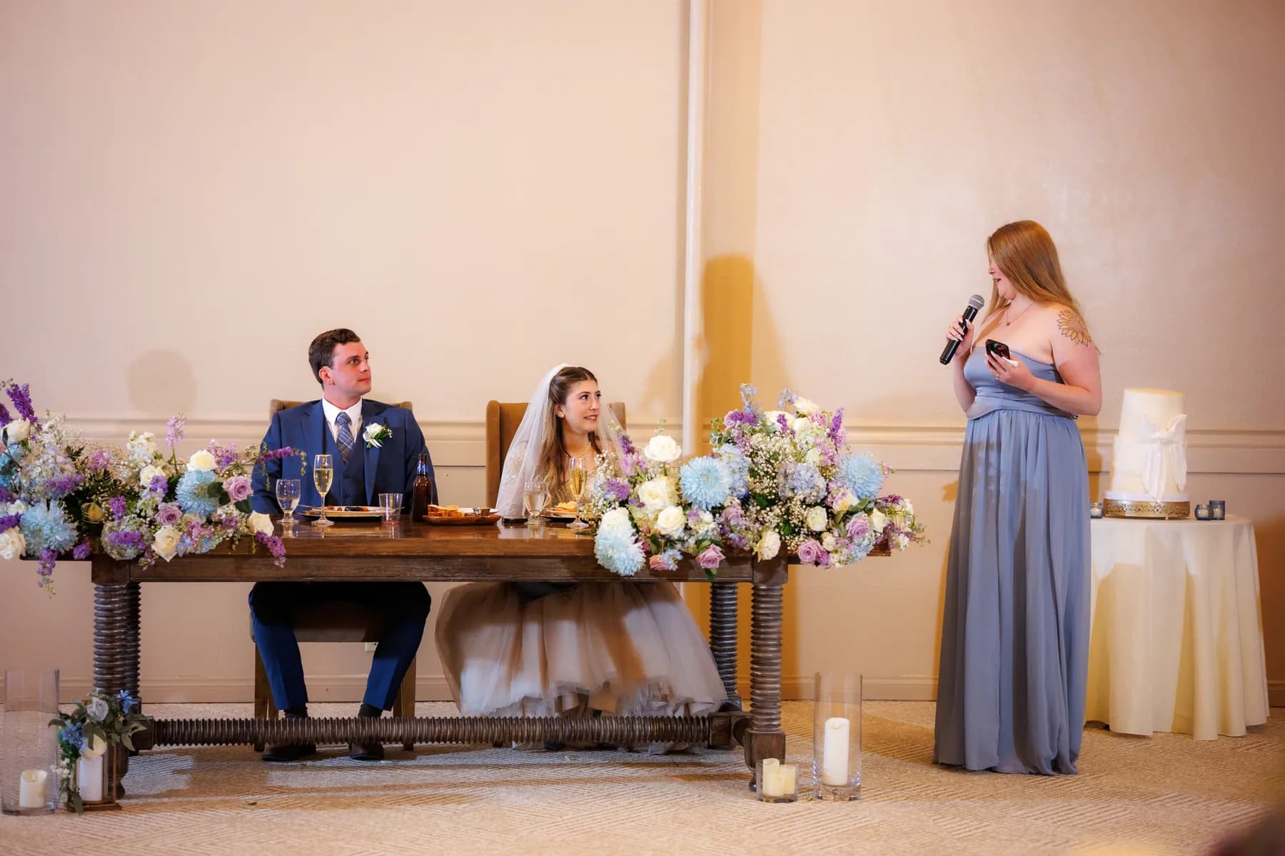 A woman speaking beside Gloria and Ryan at a decorated table