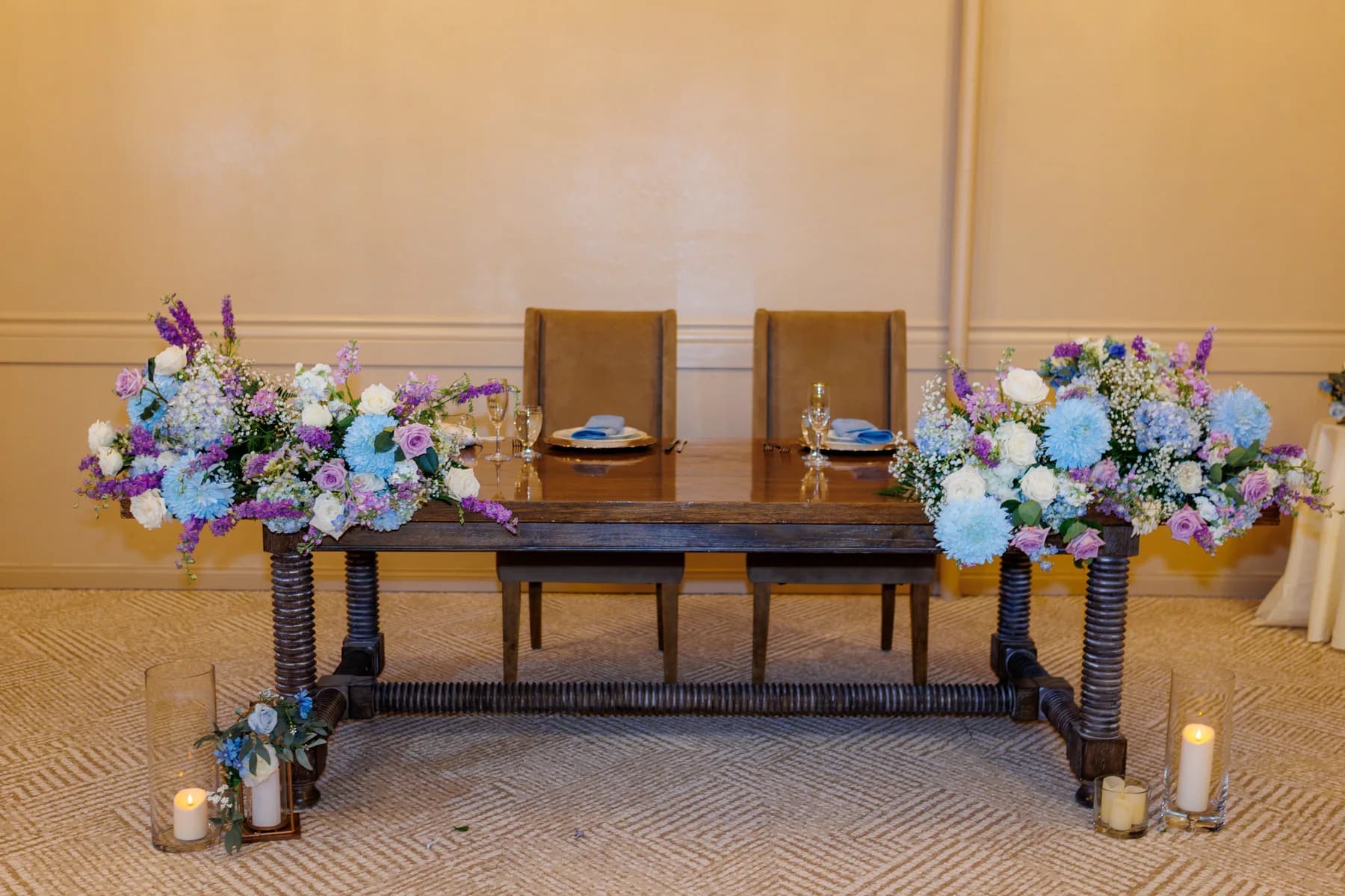 Blue, lavender, and white flowers surrounding a reception table