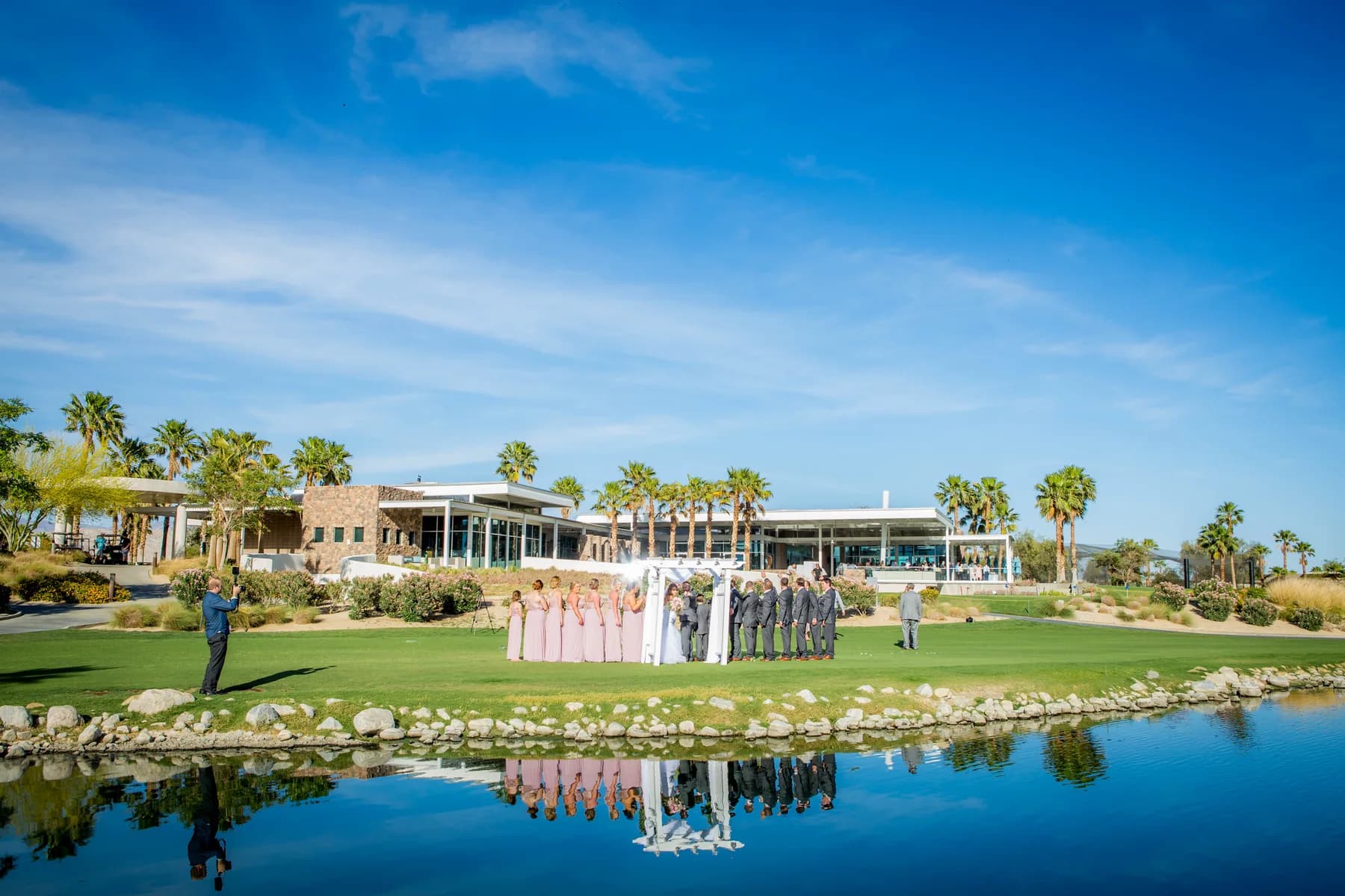 Wide view of Escena Golf Club with palm trees, water, and mountains