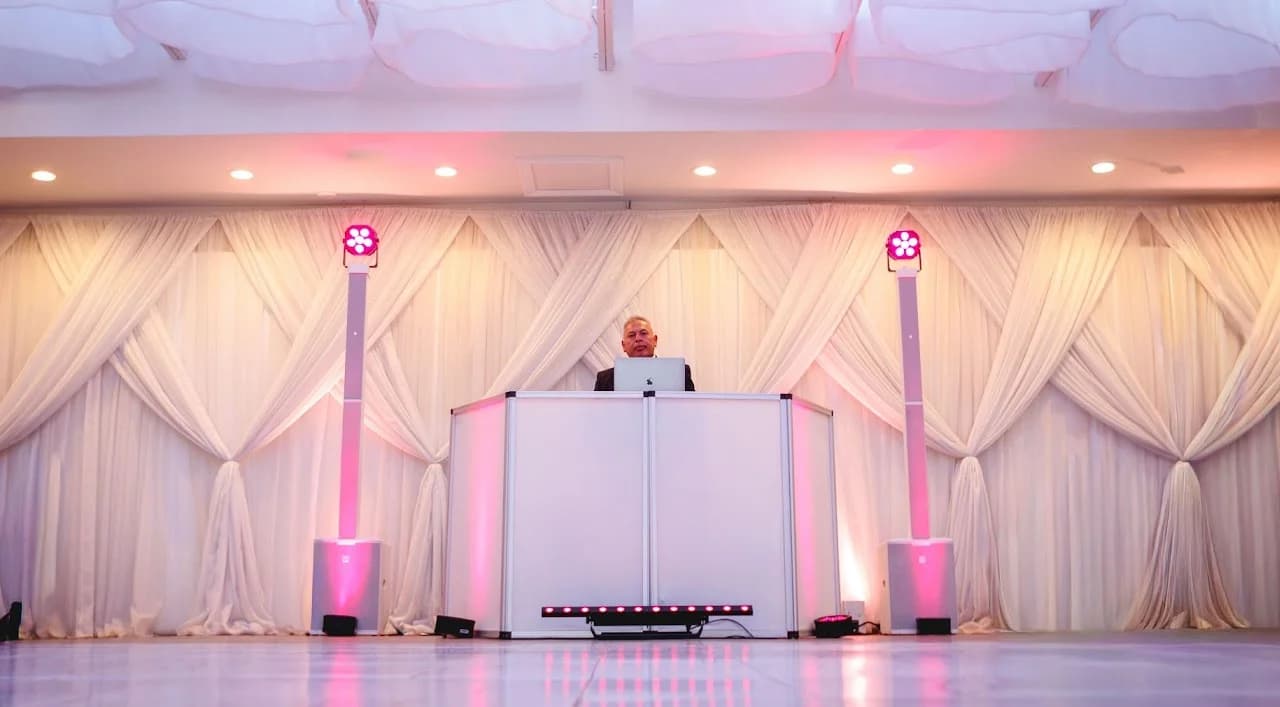 White DJ booth against illuminated drapery