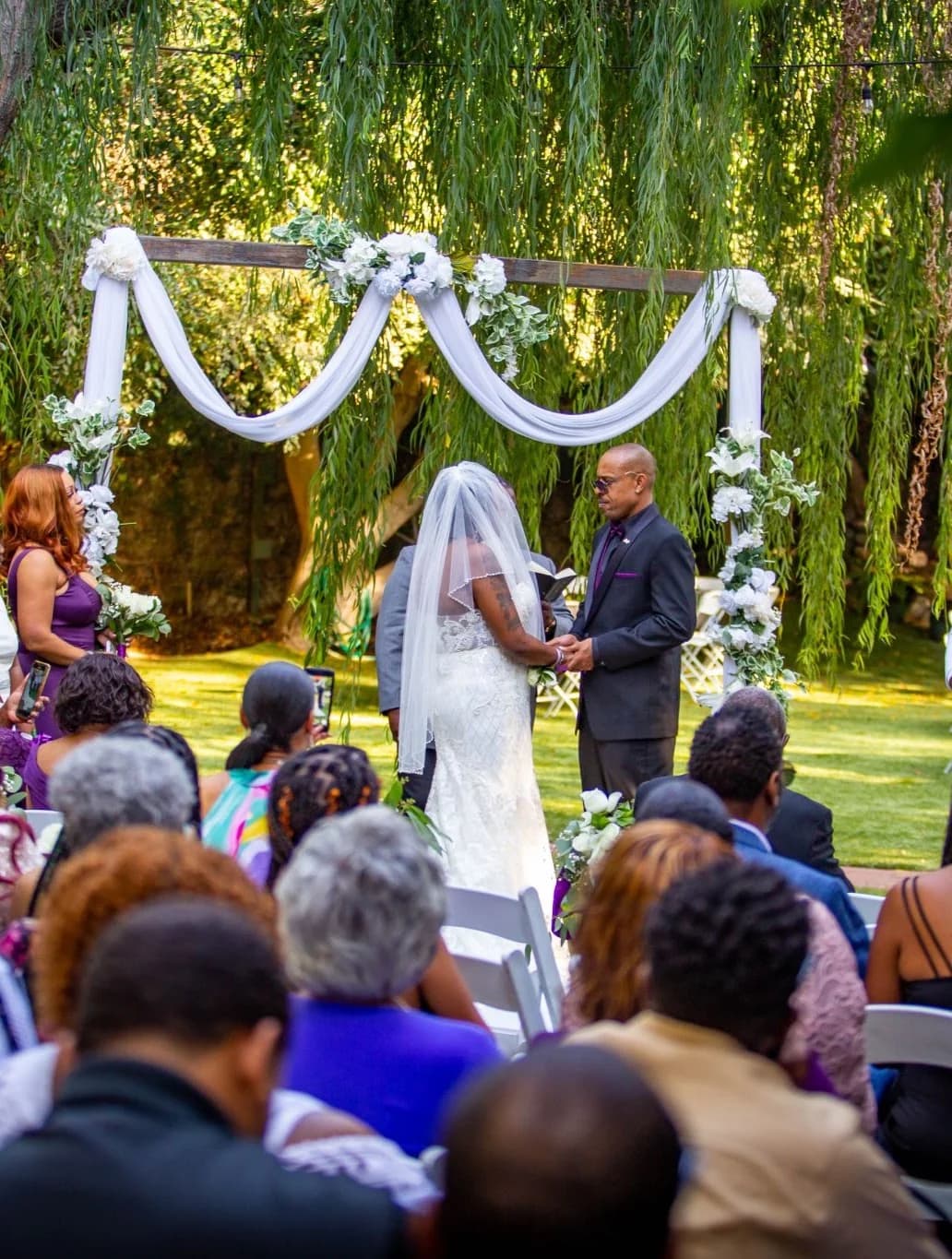 Couple standing beneath white drapery during the ceremony