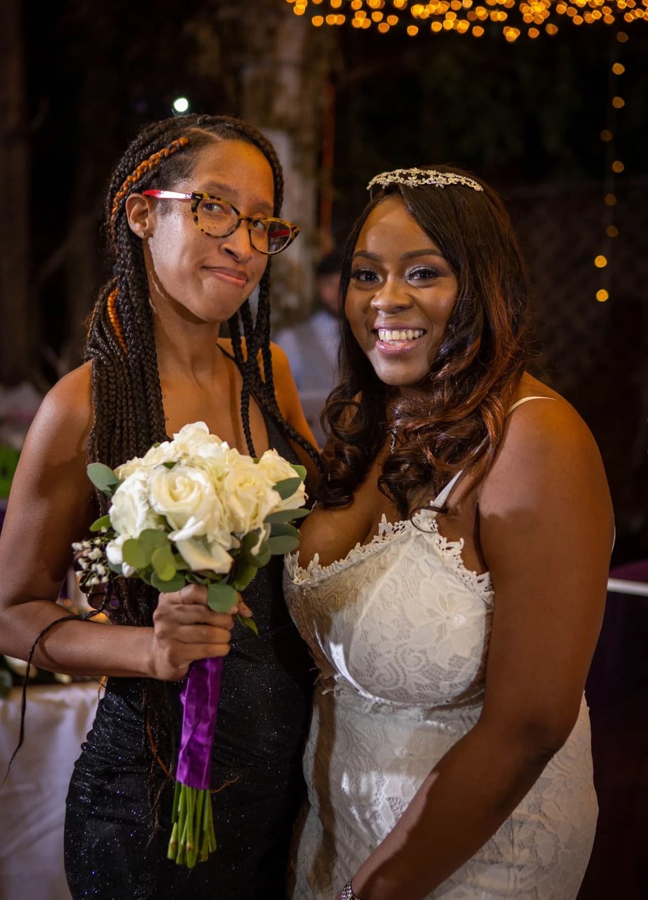 Bride smiling beside a guest holding a microphone