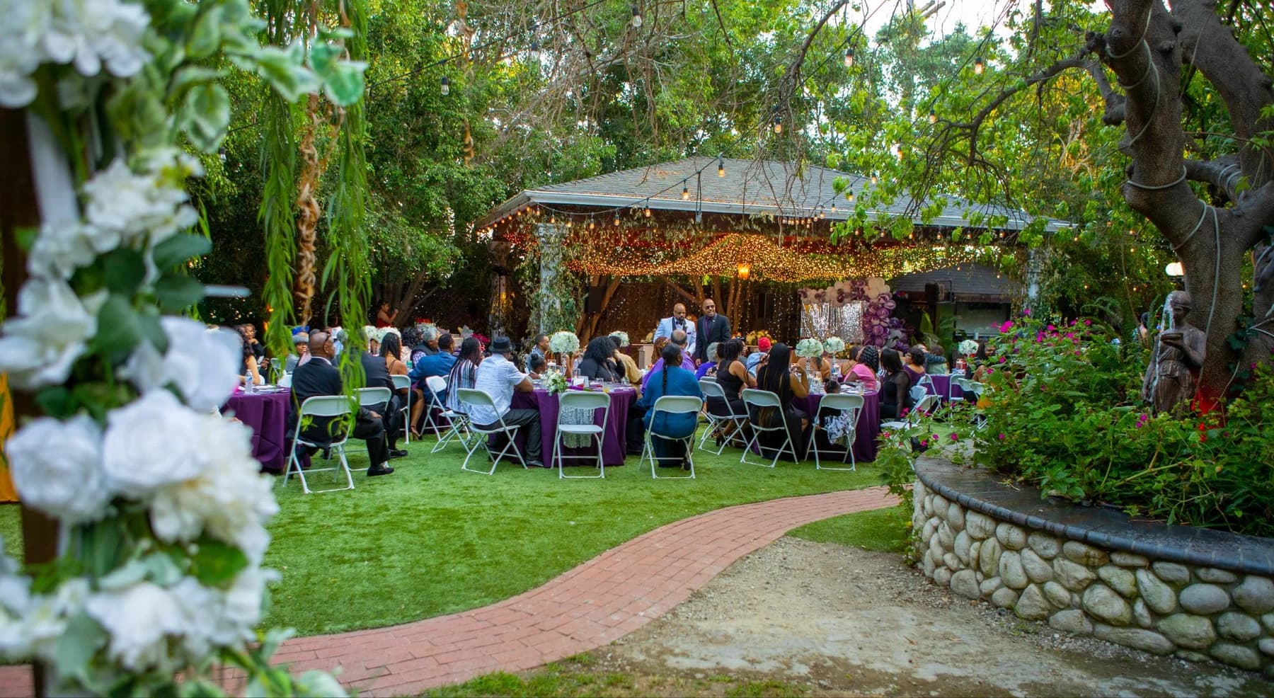 Garden ceremony viewed across the lawn and stone path