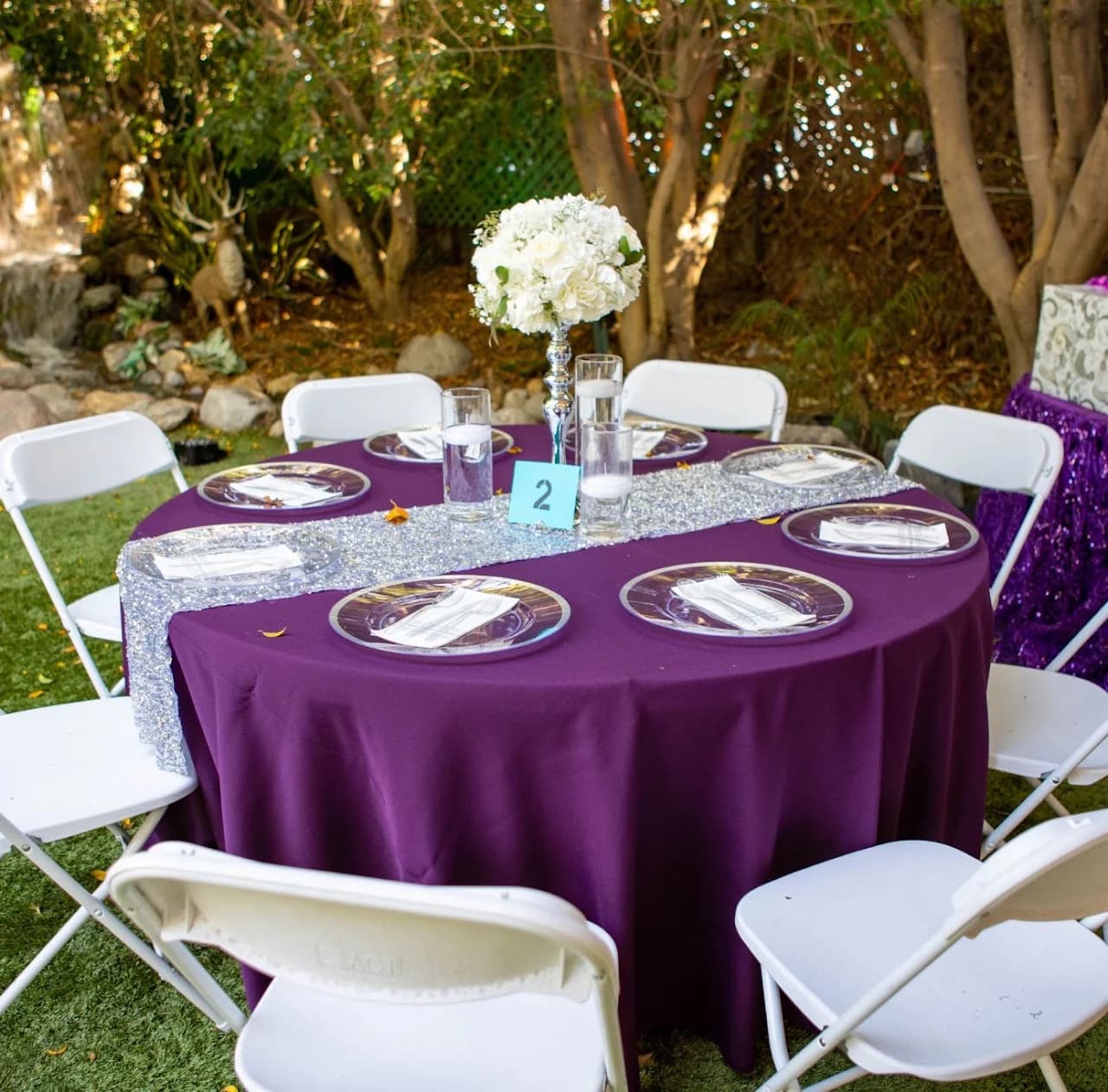 Purple tablecloth and white floral centerpiece