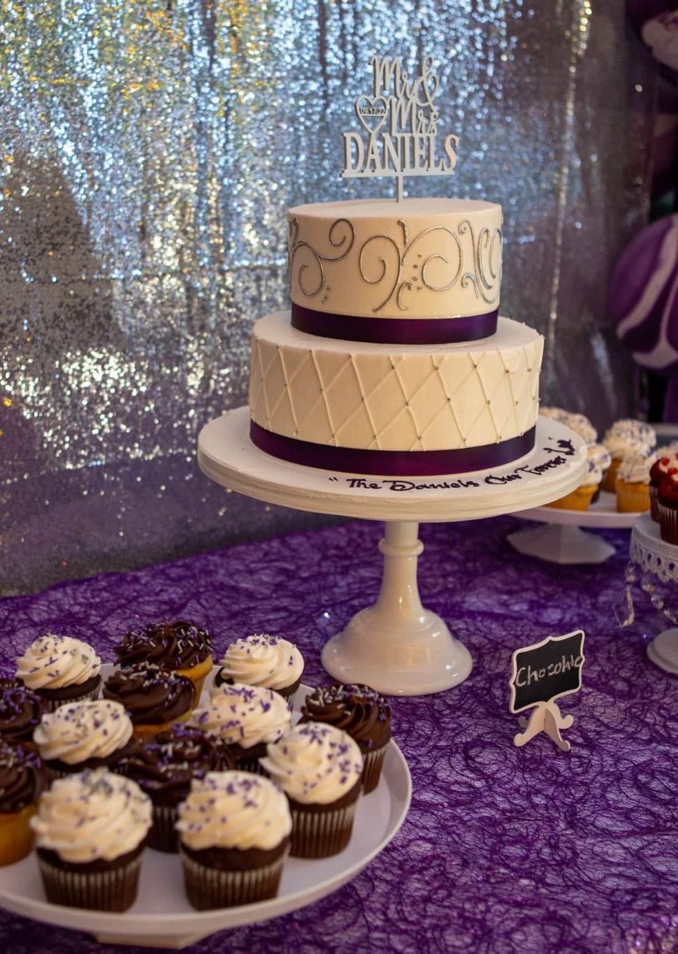 Tiered cake and cupcakes on a decorated table