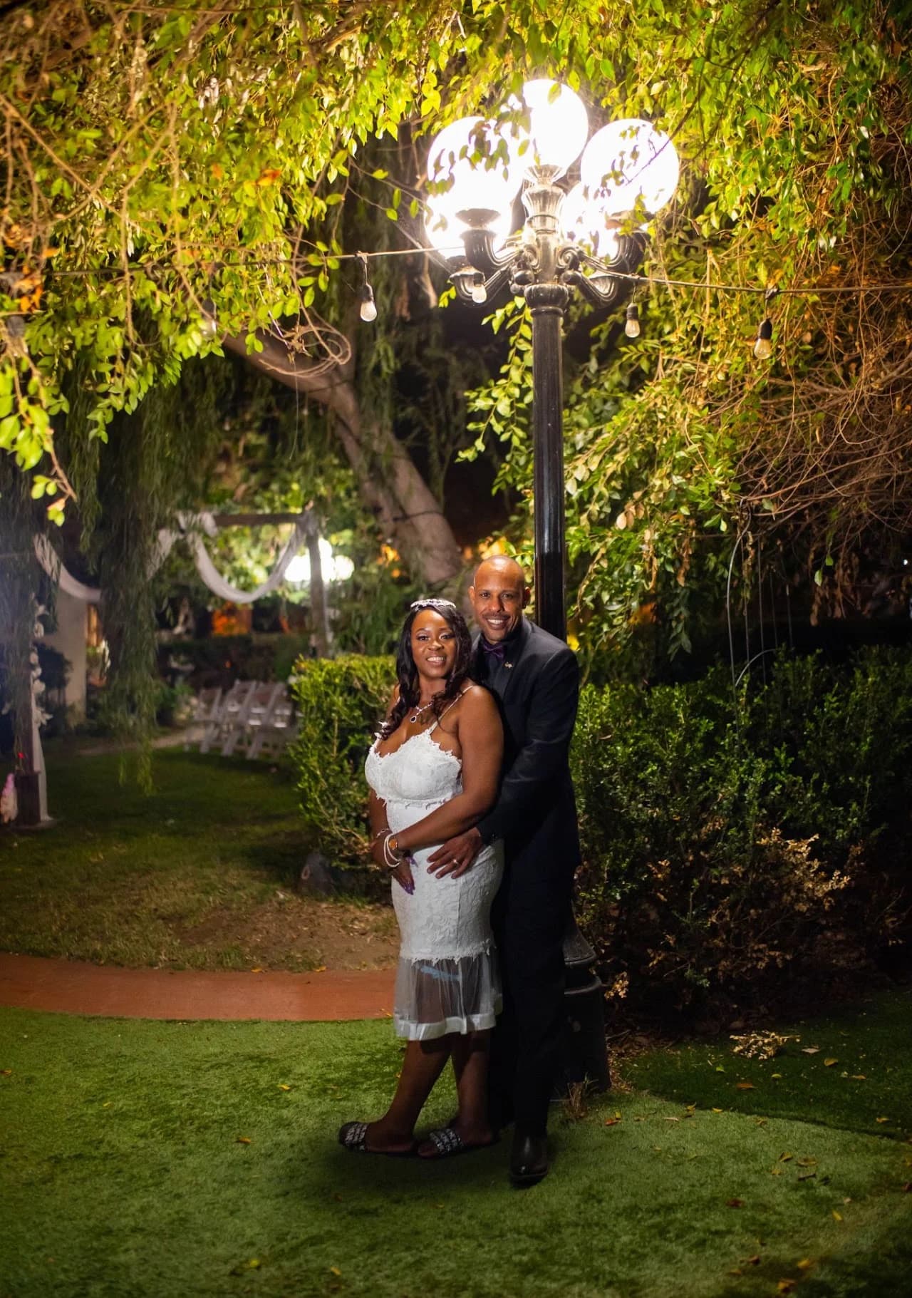 Couple beside an illuminated garden lamp