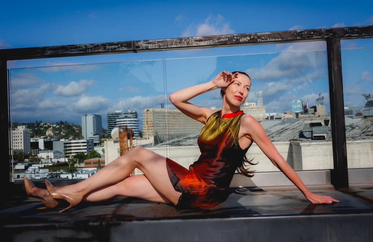 Seated rooftop fashion portrait in a multicolored dress